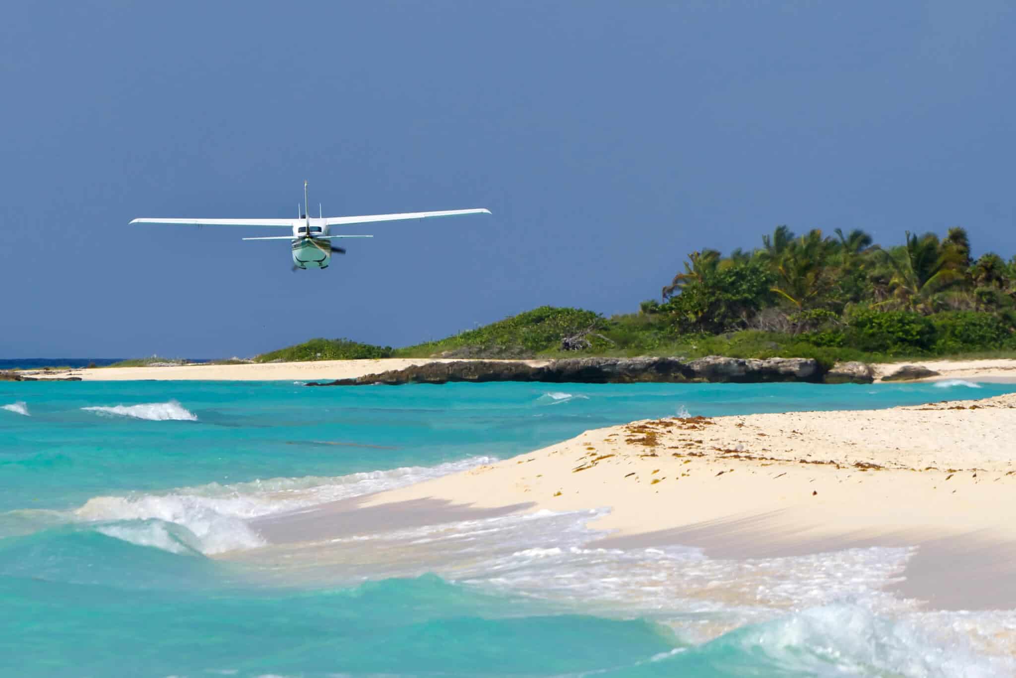 Aircraft over Caribbean beach — pilot EDC gear for overwater flights