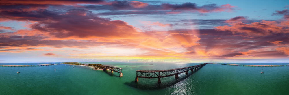 Aerial view of the Florida Keys bridge at sunset during a cinematic flight.