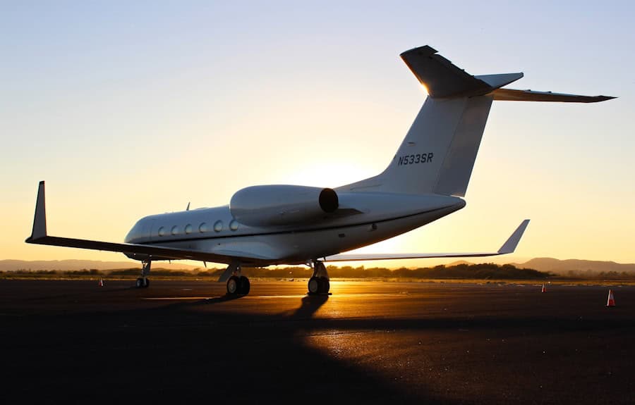Private jet parked on runway during sunset with scenic sky background.