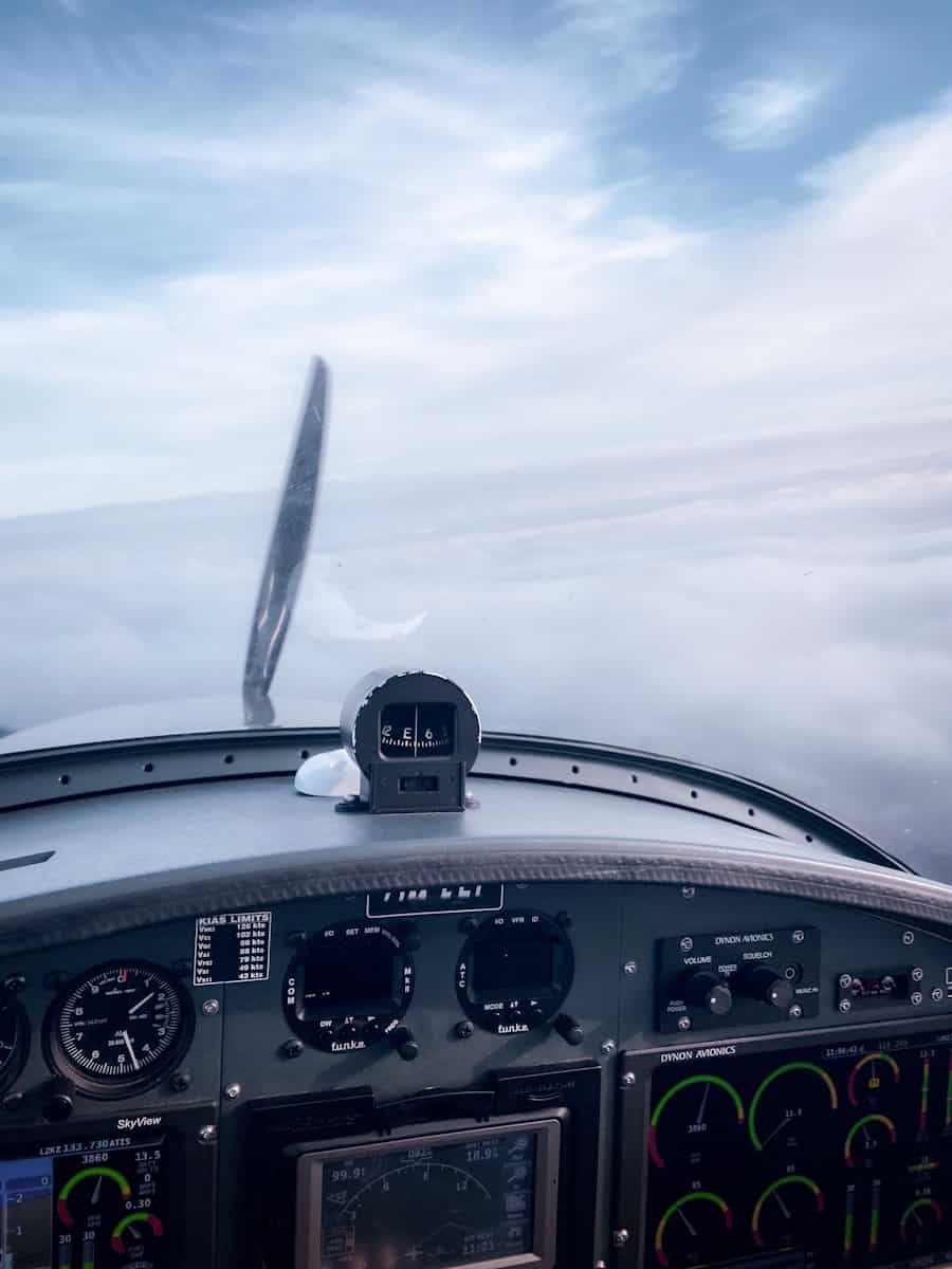 Aircraft cockpit with navigation instruments and sky view.