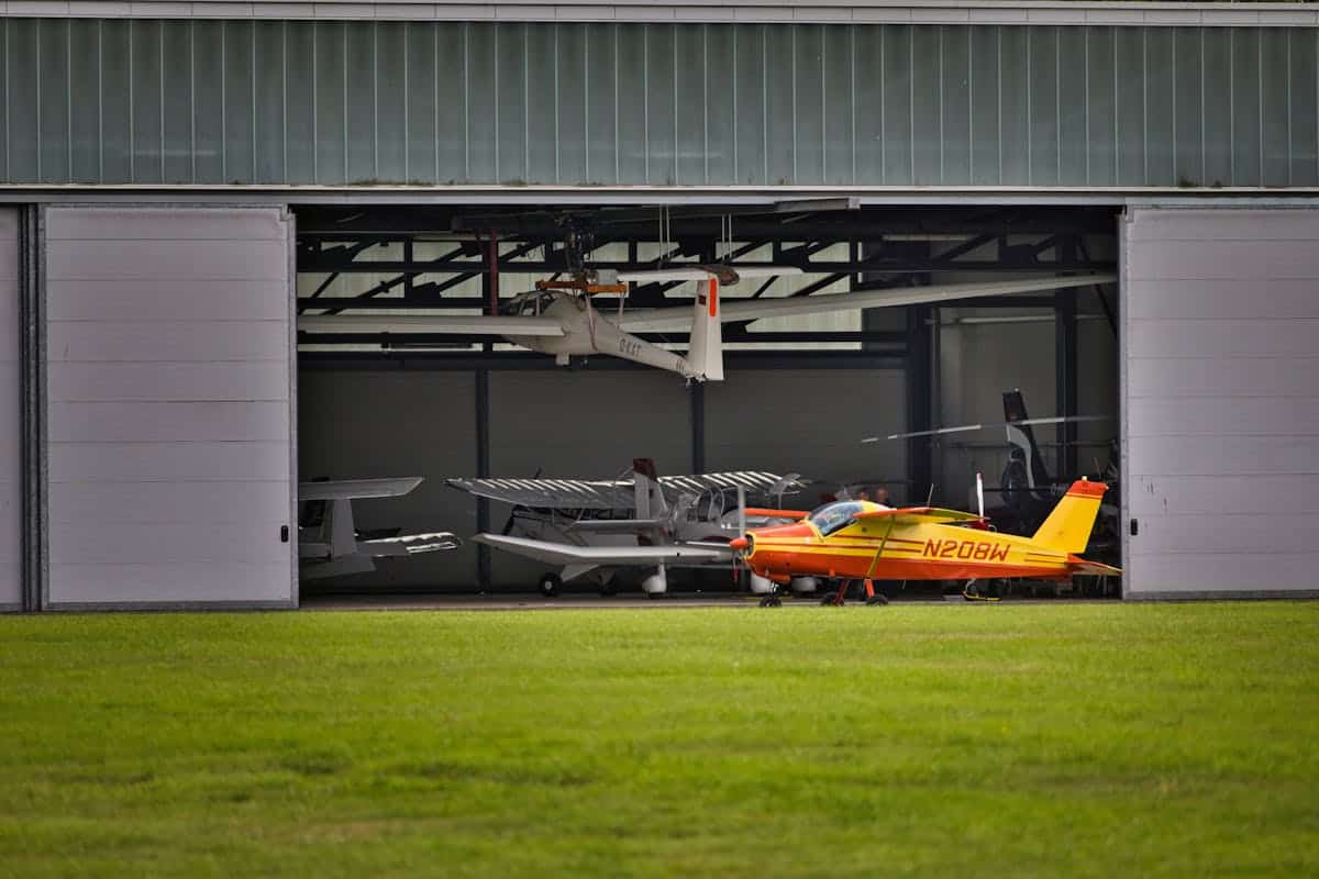 Aircraft hangar with small planes and a drone inside.