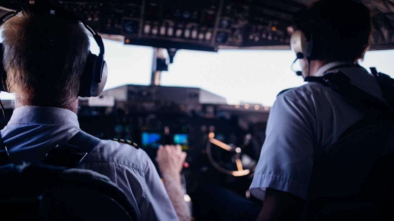 General aviation pilot in cockpit monitoring instruments during flight