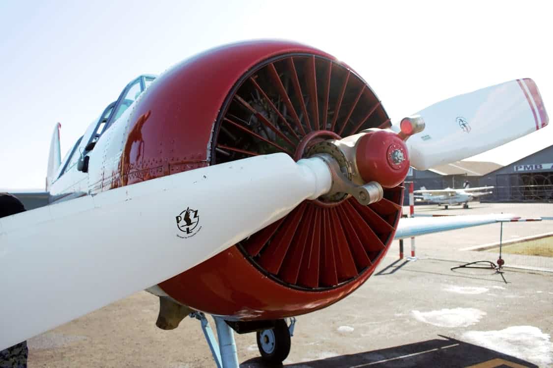 Red and white propeller aircraft on the tarmac — typical general aviation piston aircraft affected by the Lycoming connecting rod bushing AD