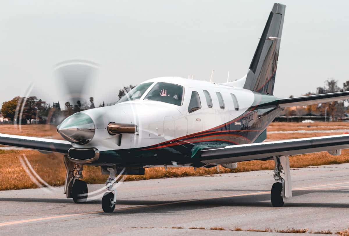 White general aviation single engine airplane parked on airport tarmac ready for flight