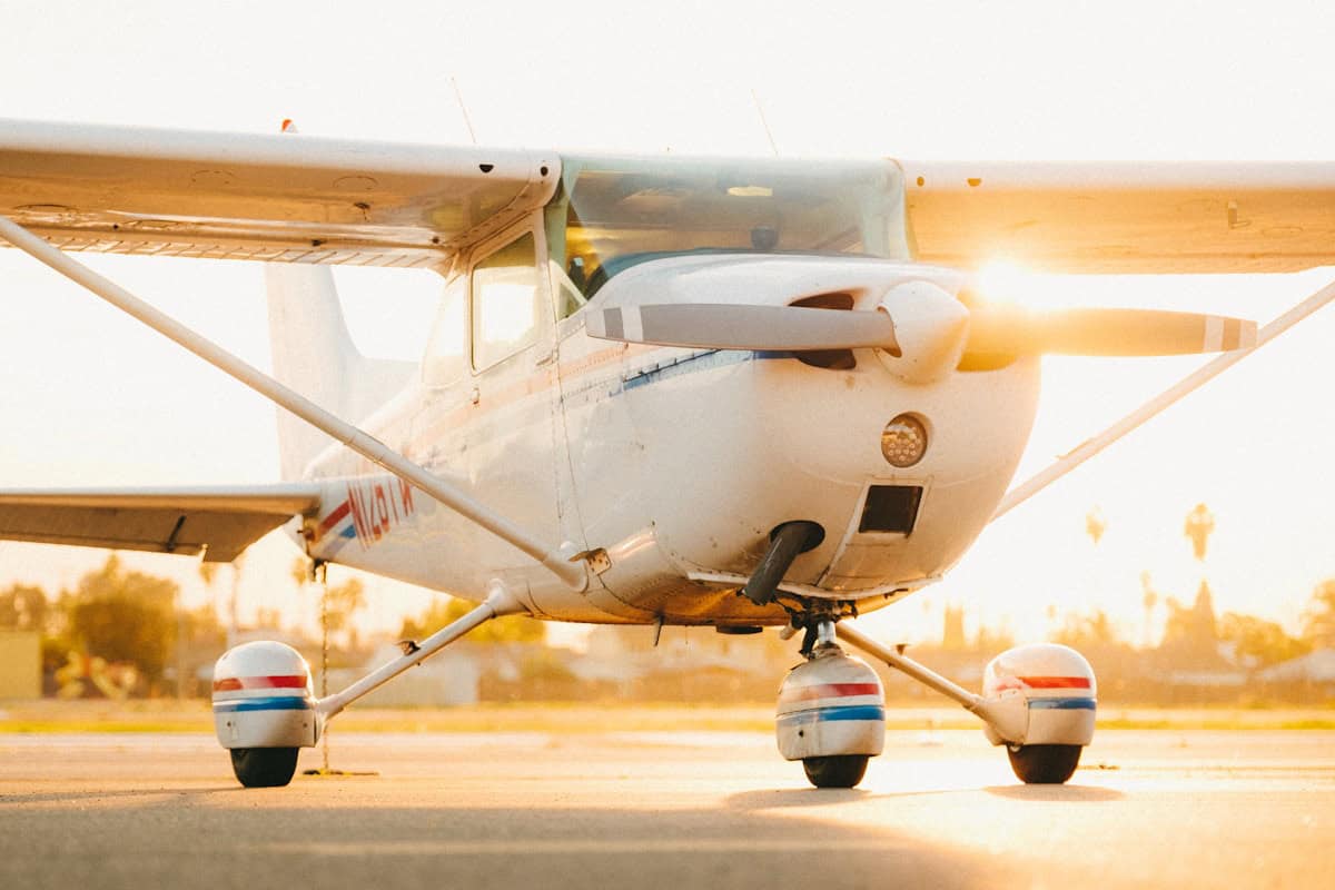 Small private airplane on runway at sunset.