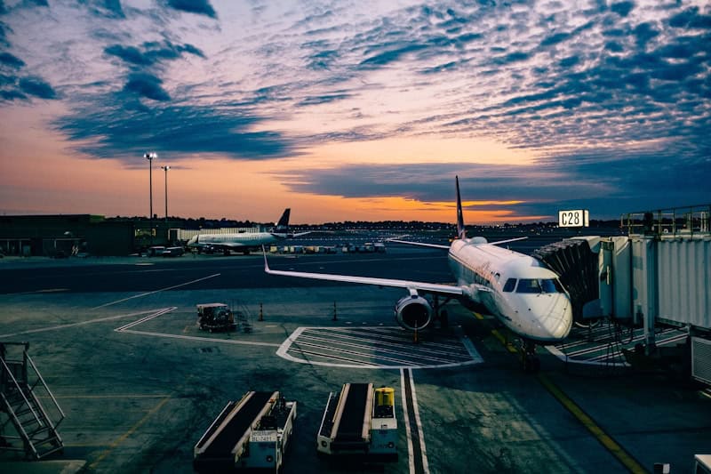 Aircraft parked at airport gate during sunset.
