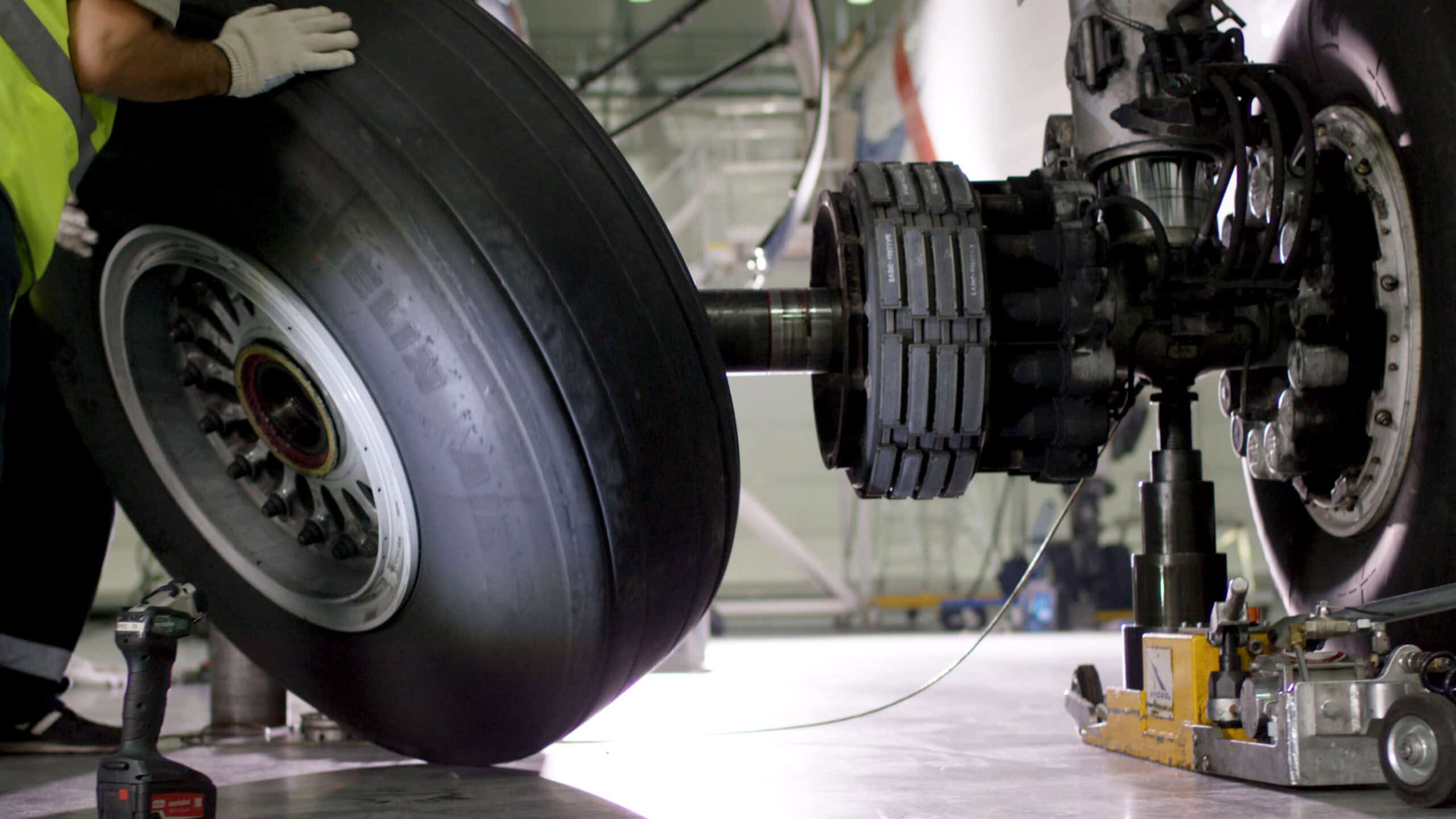 Airport ground worker checking aircraft chassis