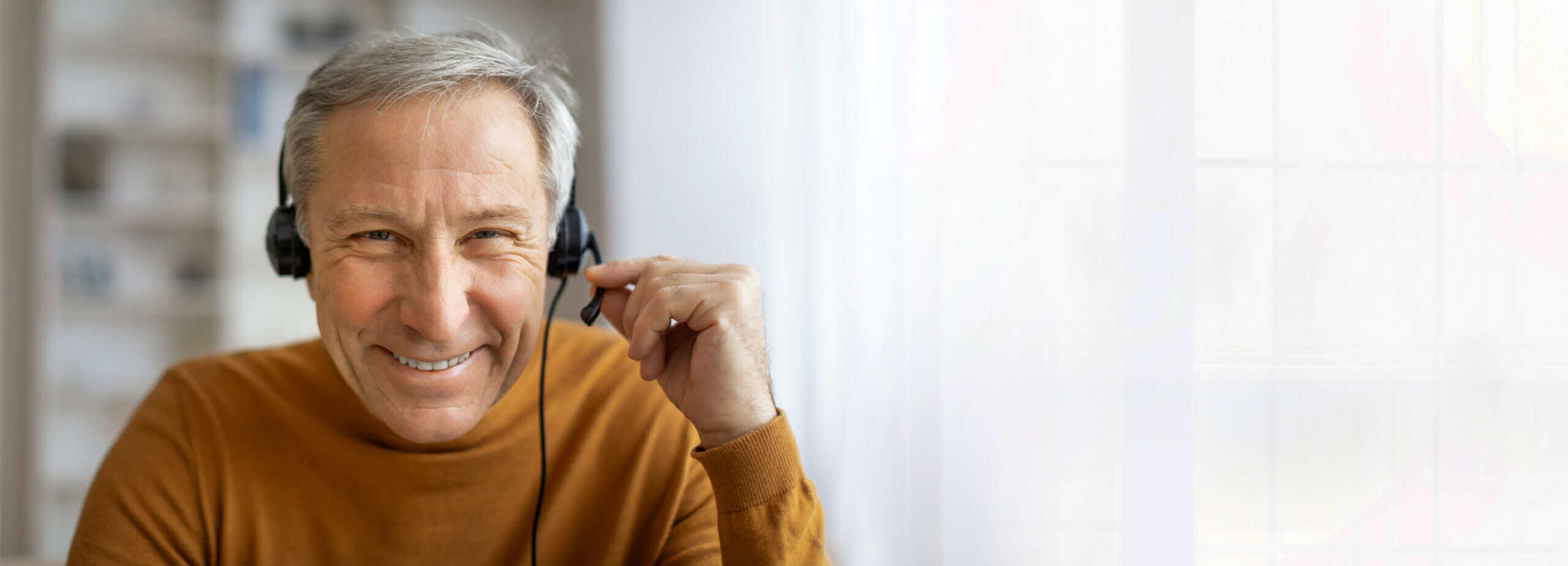 Senior man wearing a pilot headset and smiling