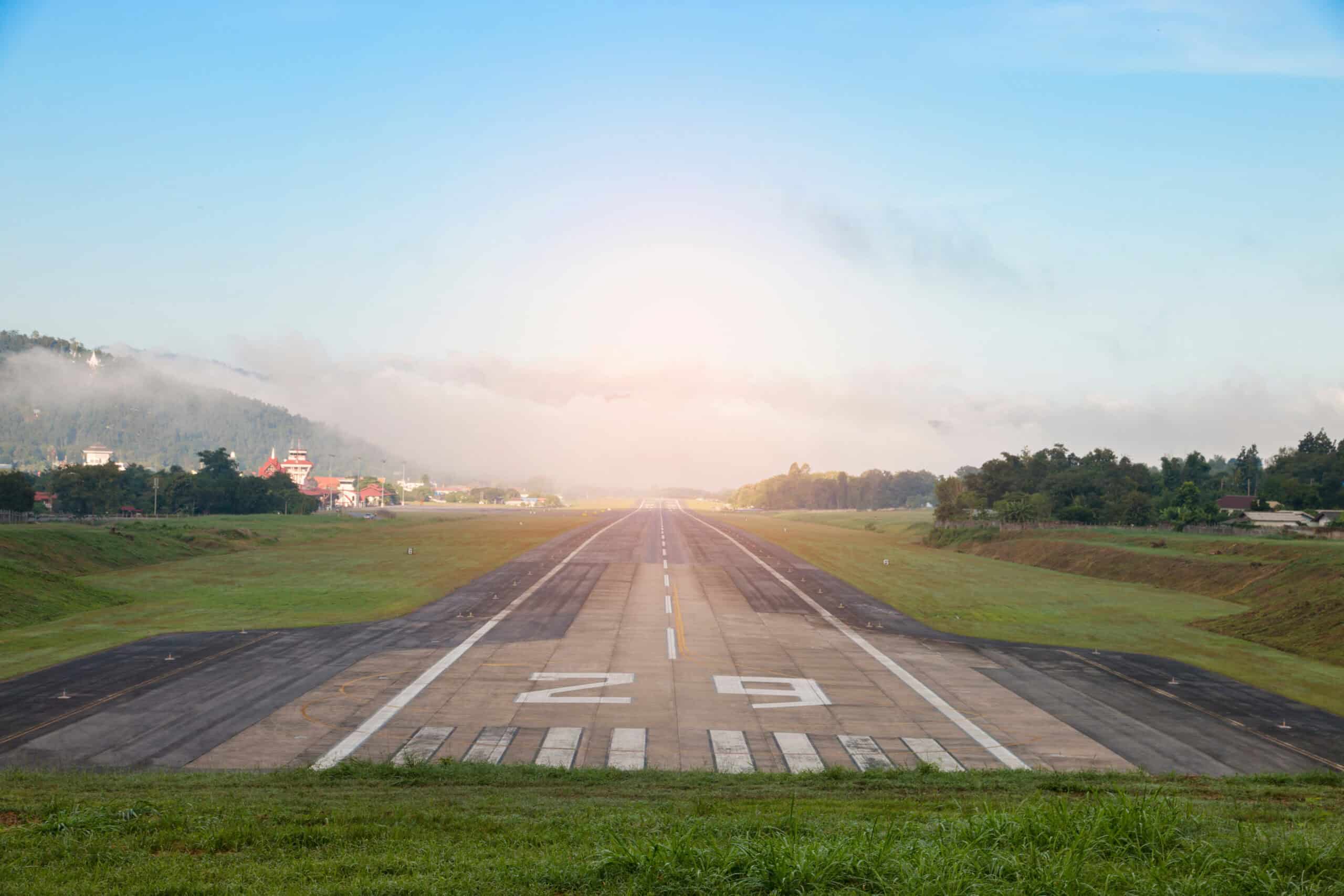 Airport runway with mountain backdrop in countryside