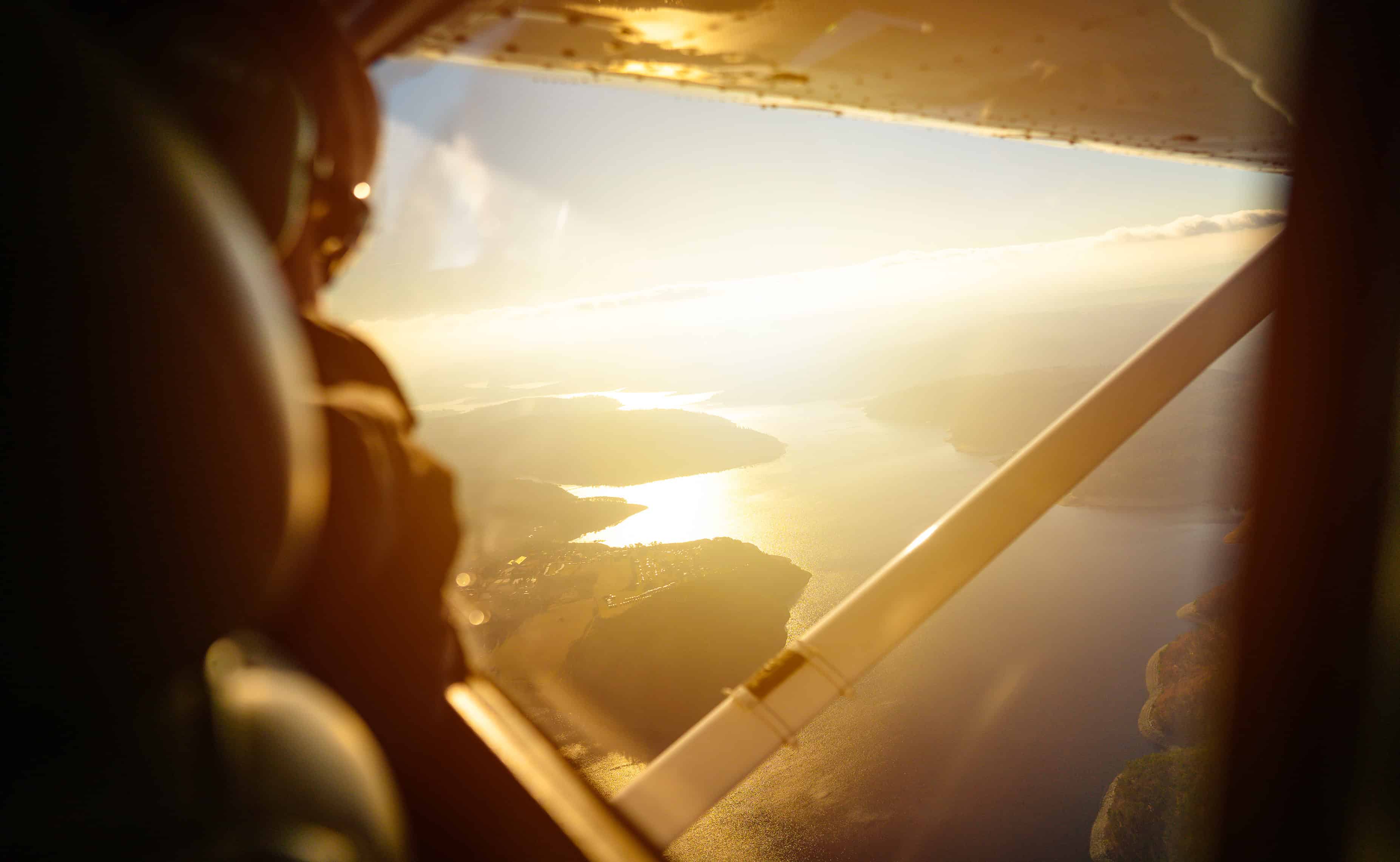 aviation weather decision-making — GA pilot view through small Cessna cockpit at sunset