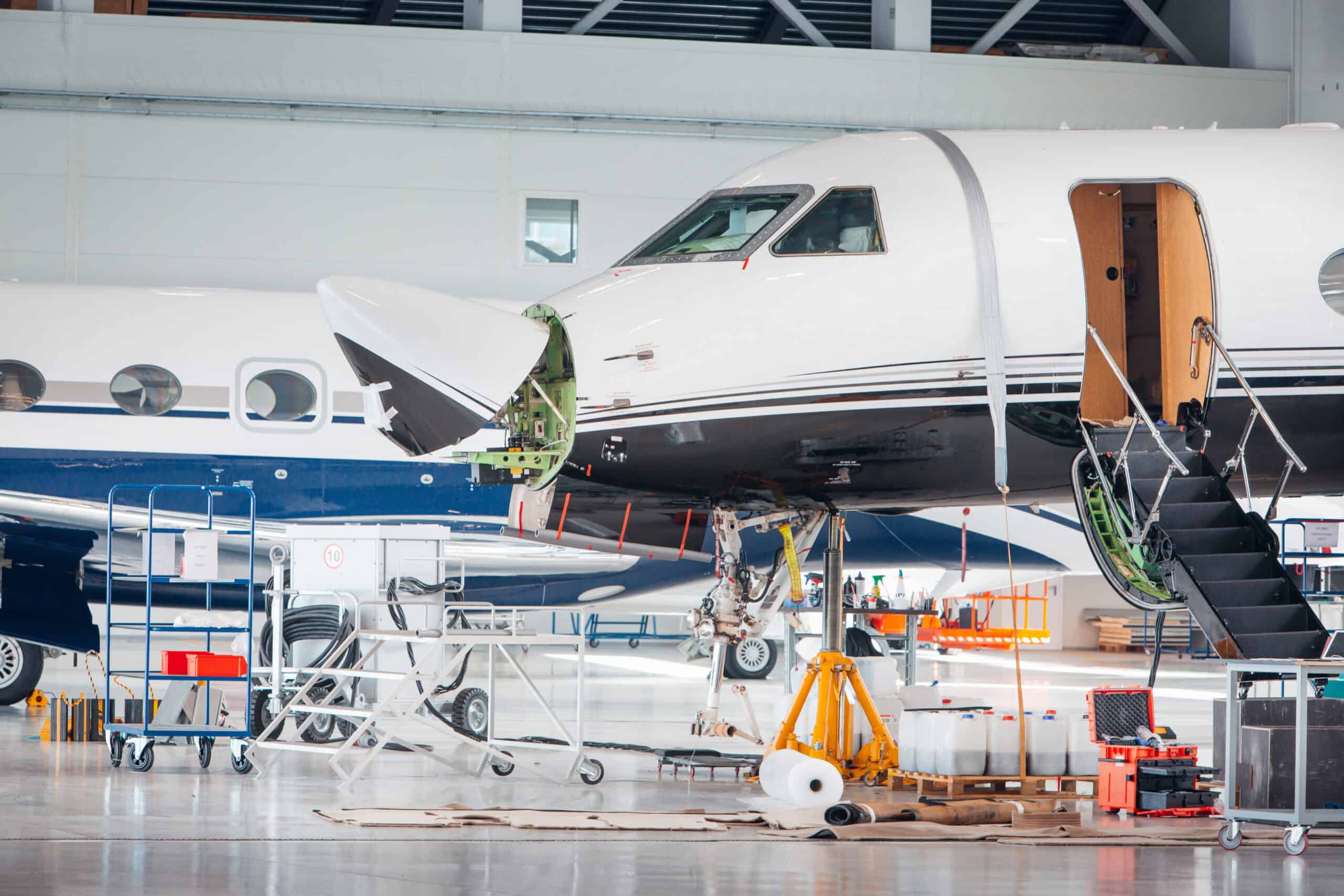 Pilot reviewing aircraft maintenance logbook and Pilatus PC-24 documentation