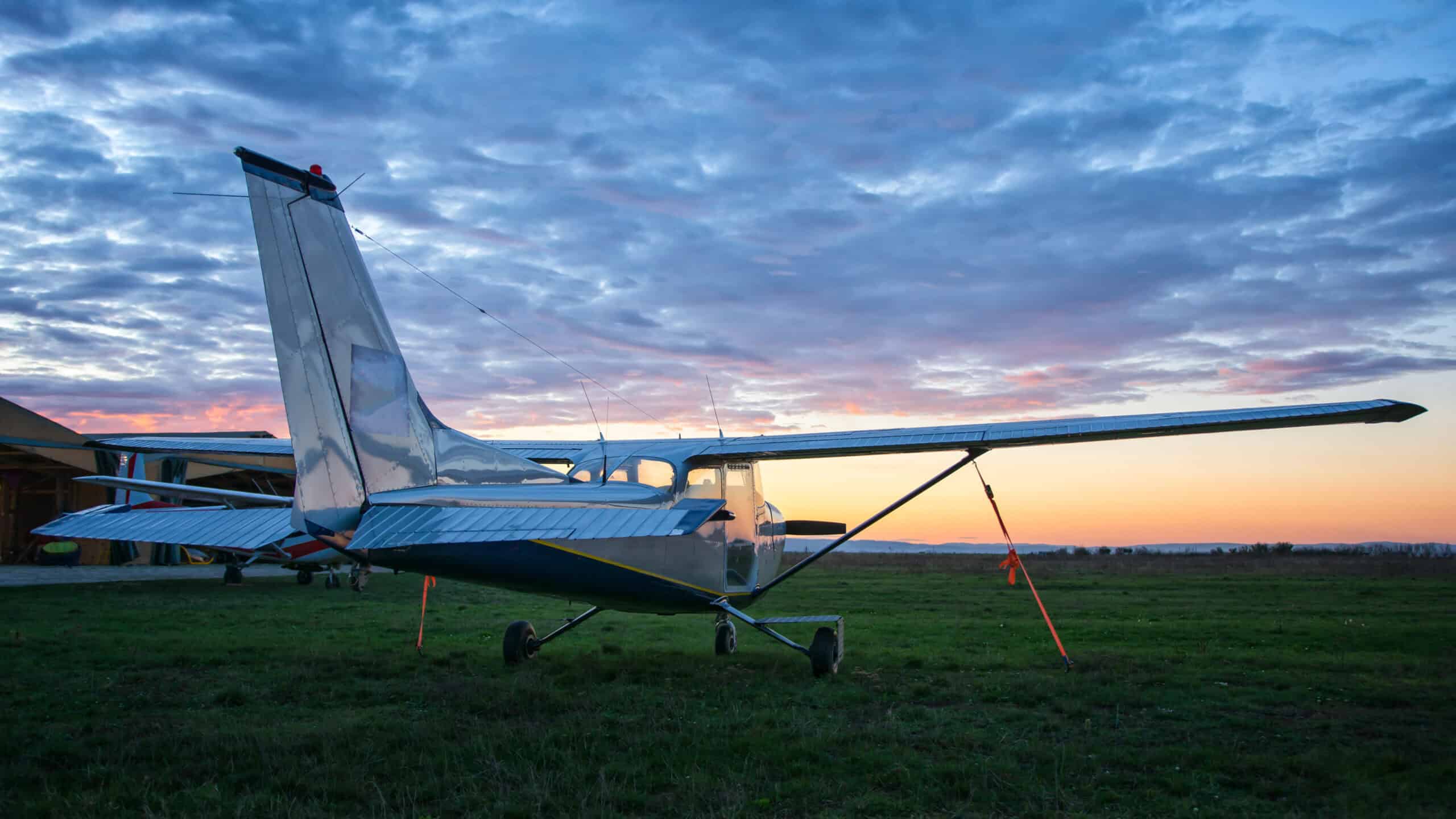 pilot camping beside cross-country airplane at remote backcountry airstrip