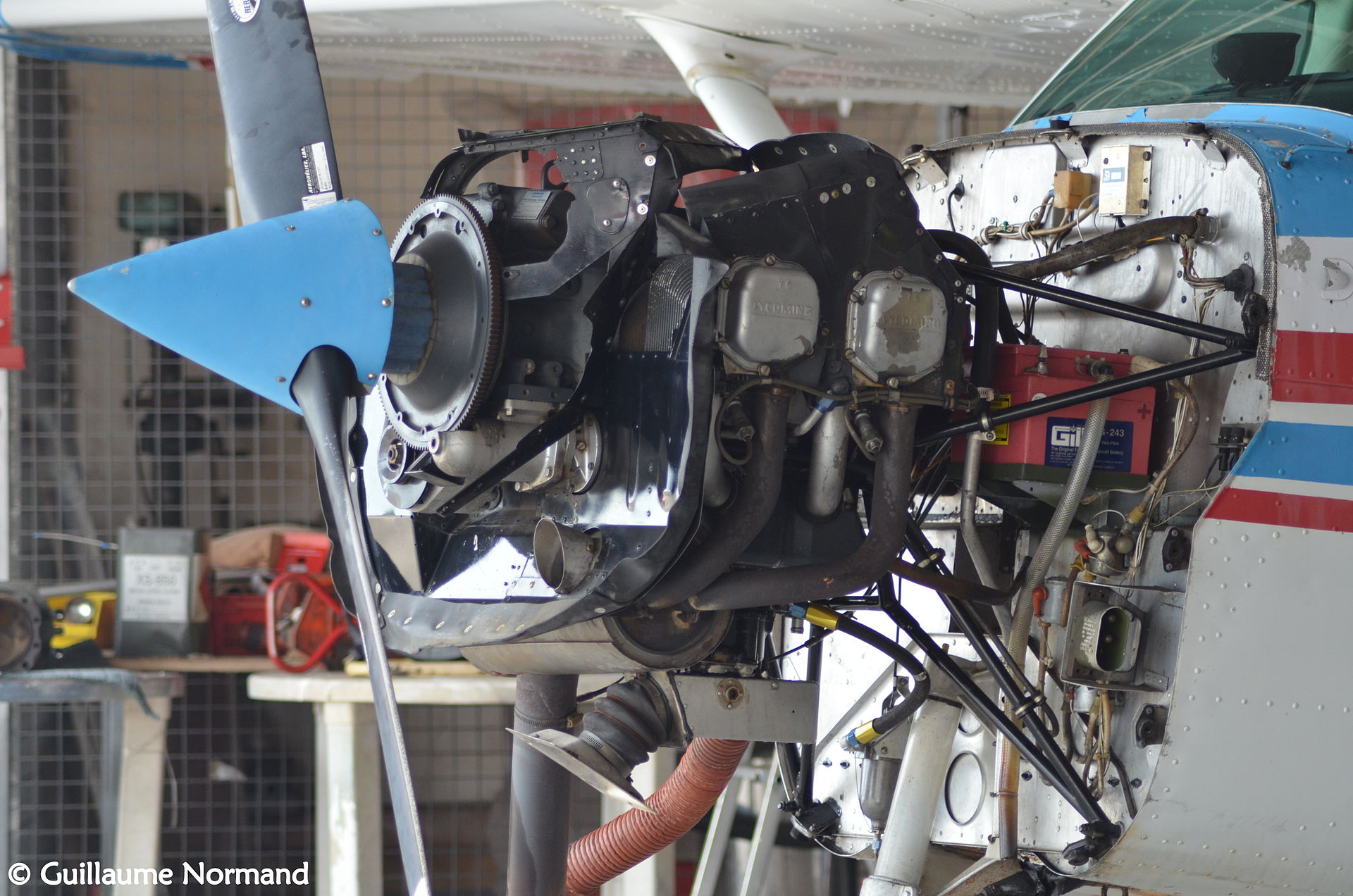Cessna piston single with cowling removed in hangar — the typical setup for an aircraft cylinder compression test during annual inspection