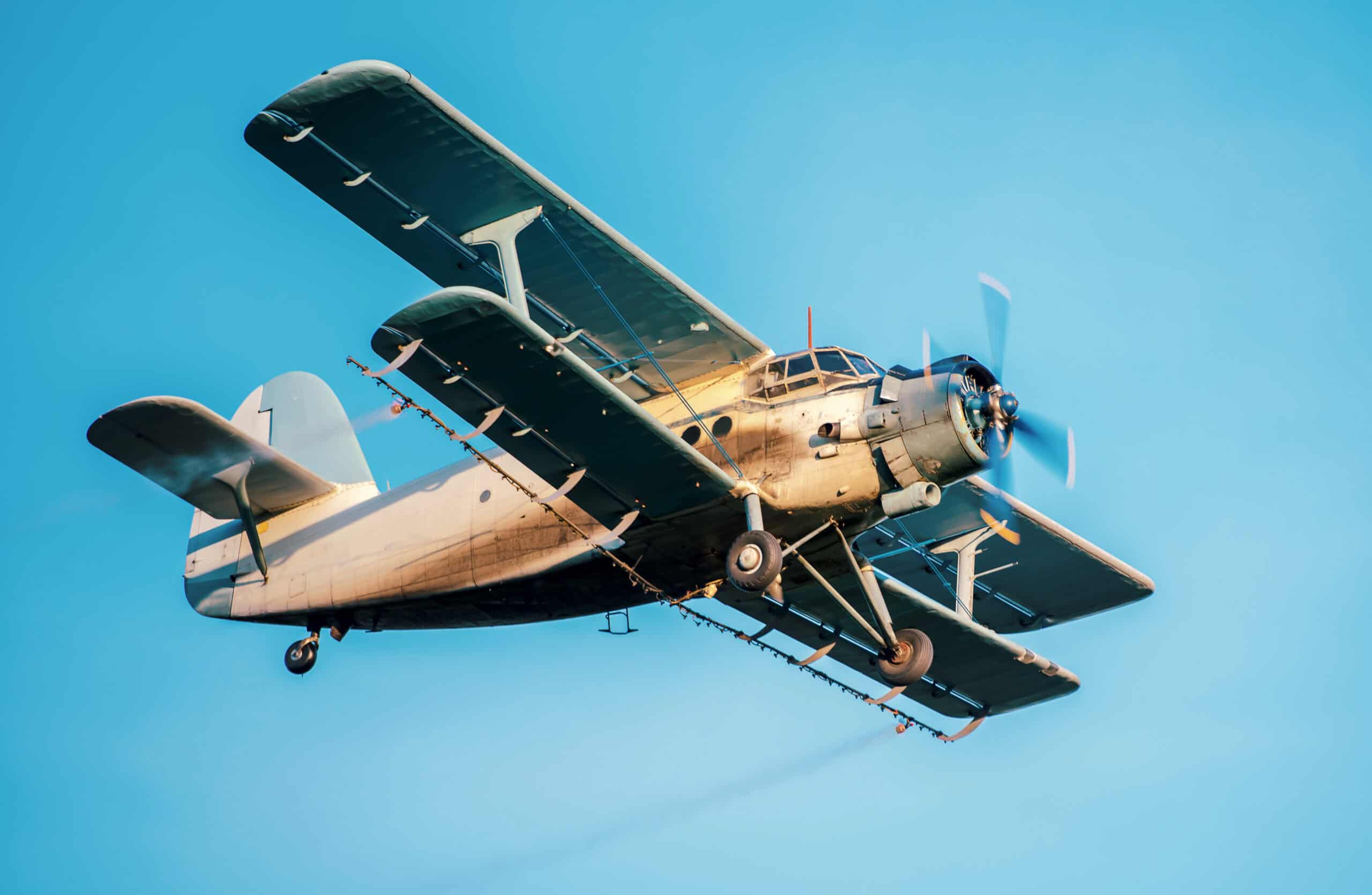 Antonov-style biplane in flight against clear blue sky