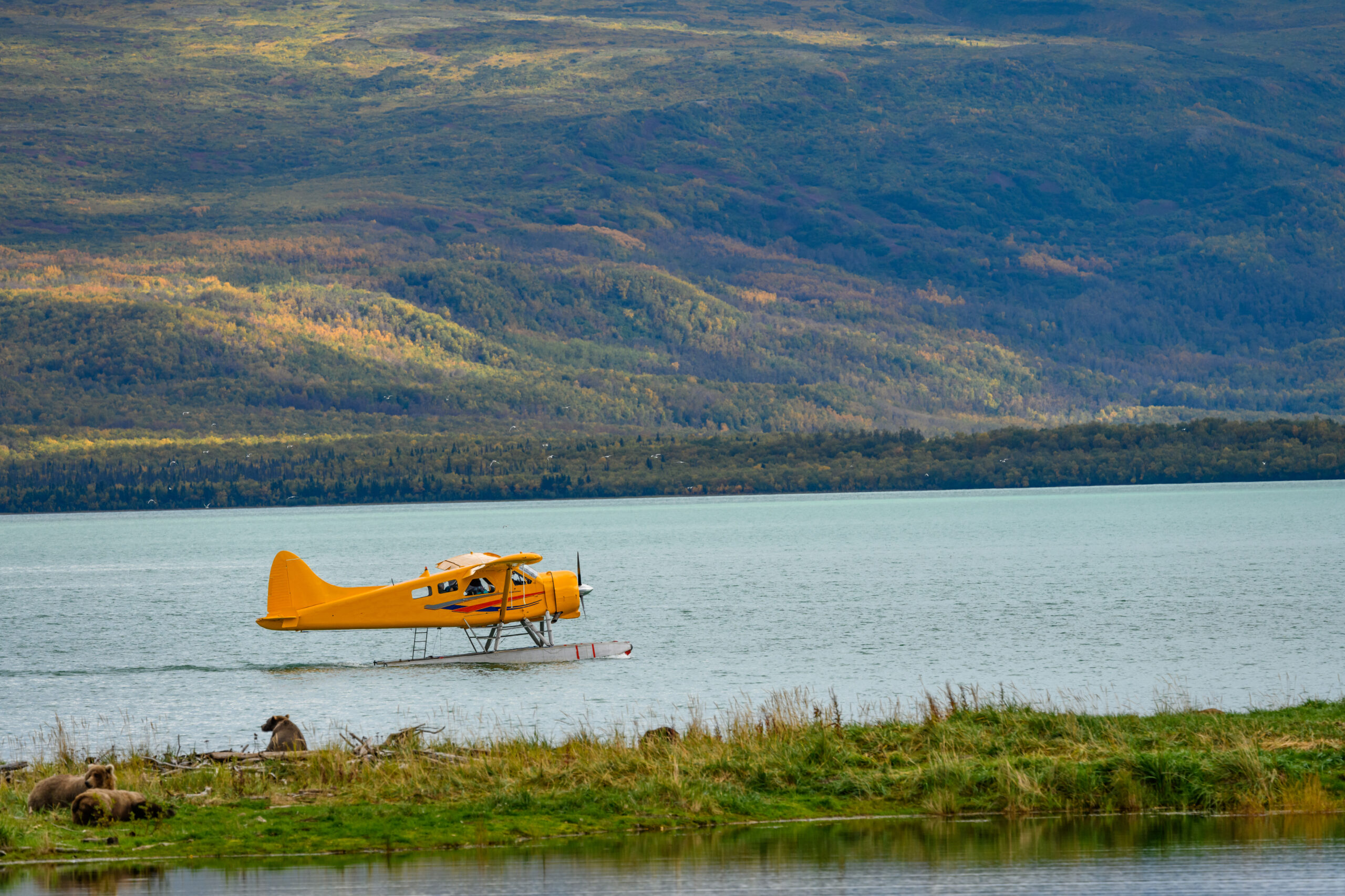Yellow floatplane on Alaska lake during fall — small piston aircraft operations rely on consistent fuel supply