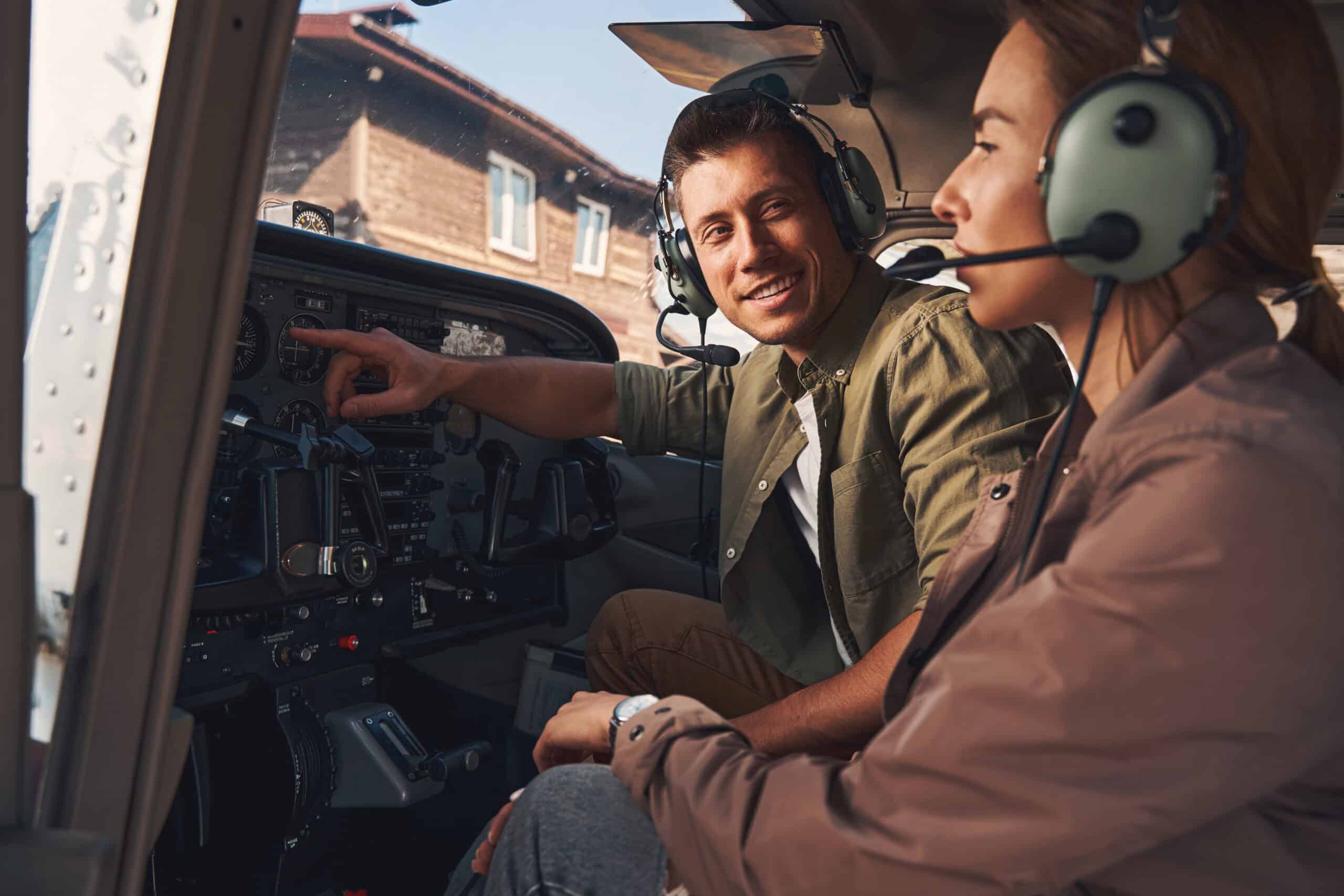 Cheerful flight instructor giving lesson to student pilot