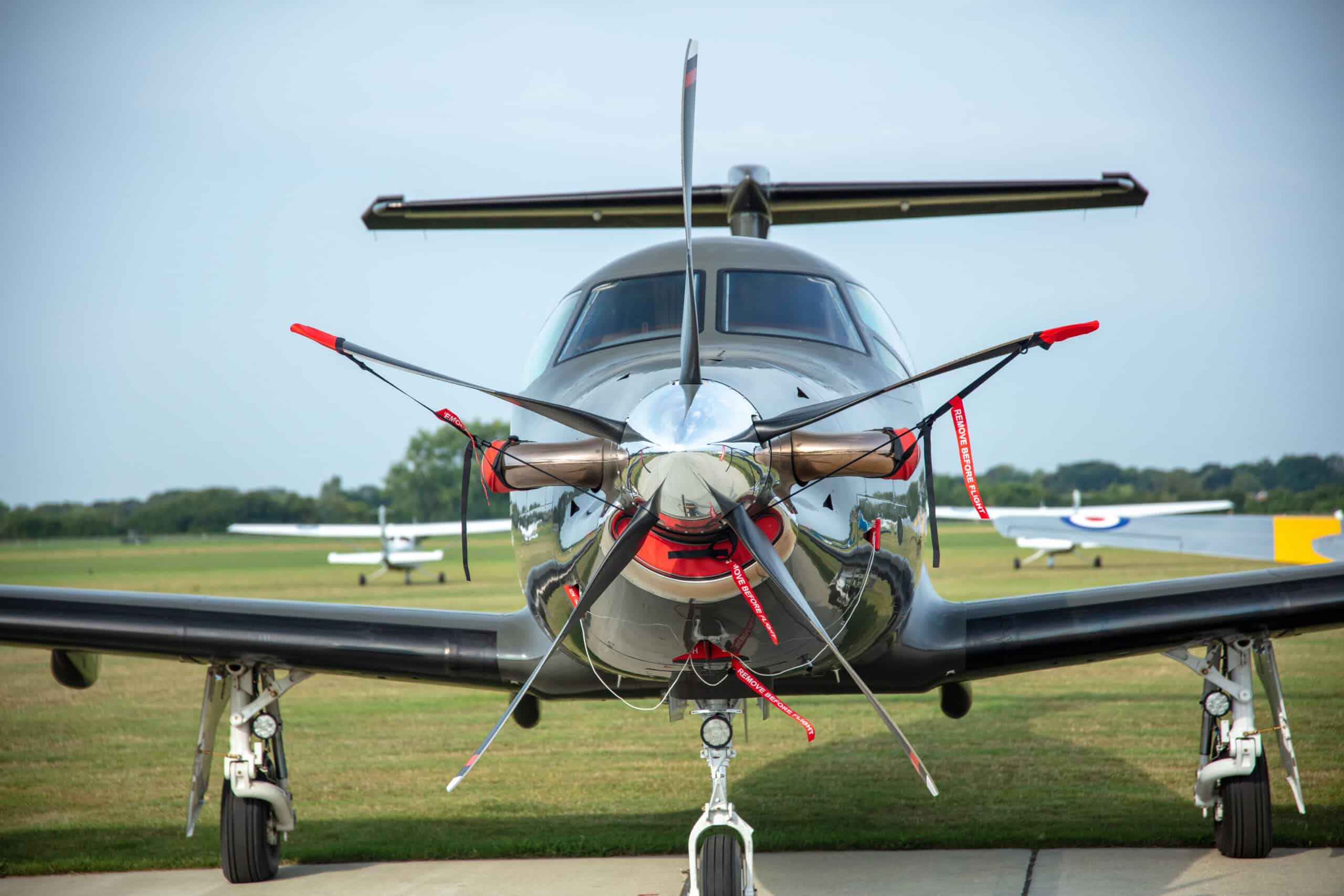 Modern turboprop aircraft on runway with clear sky background.