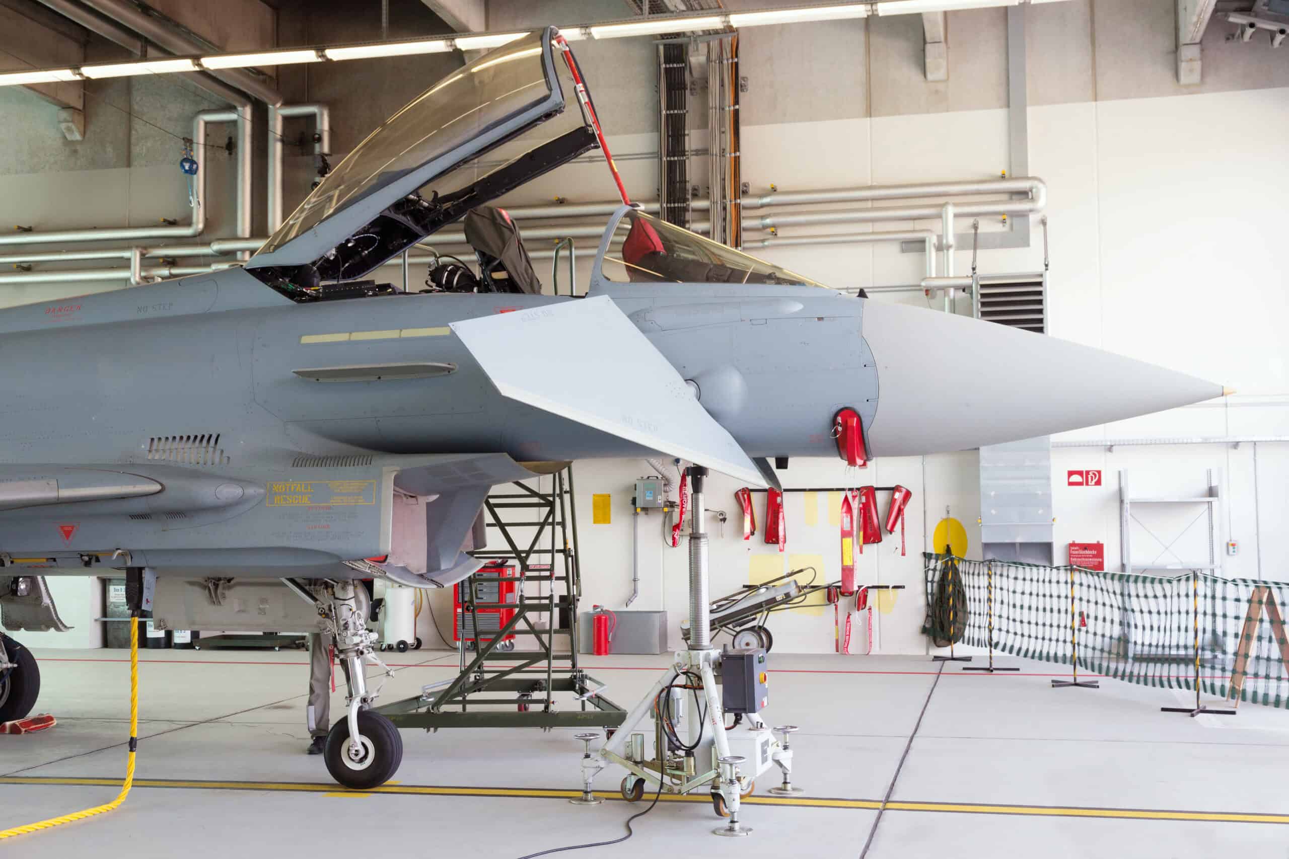Soviet fighter jet in military hangar undergoing inspection between flights