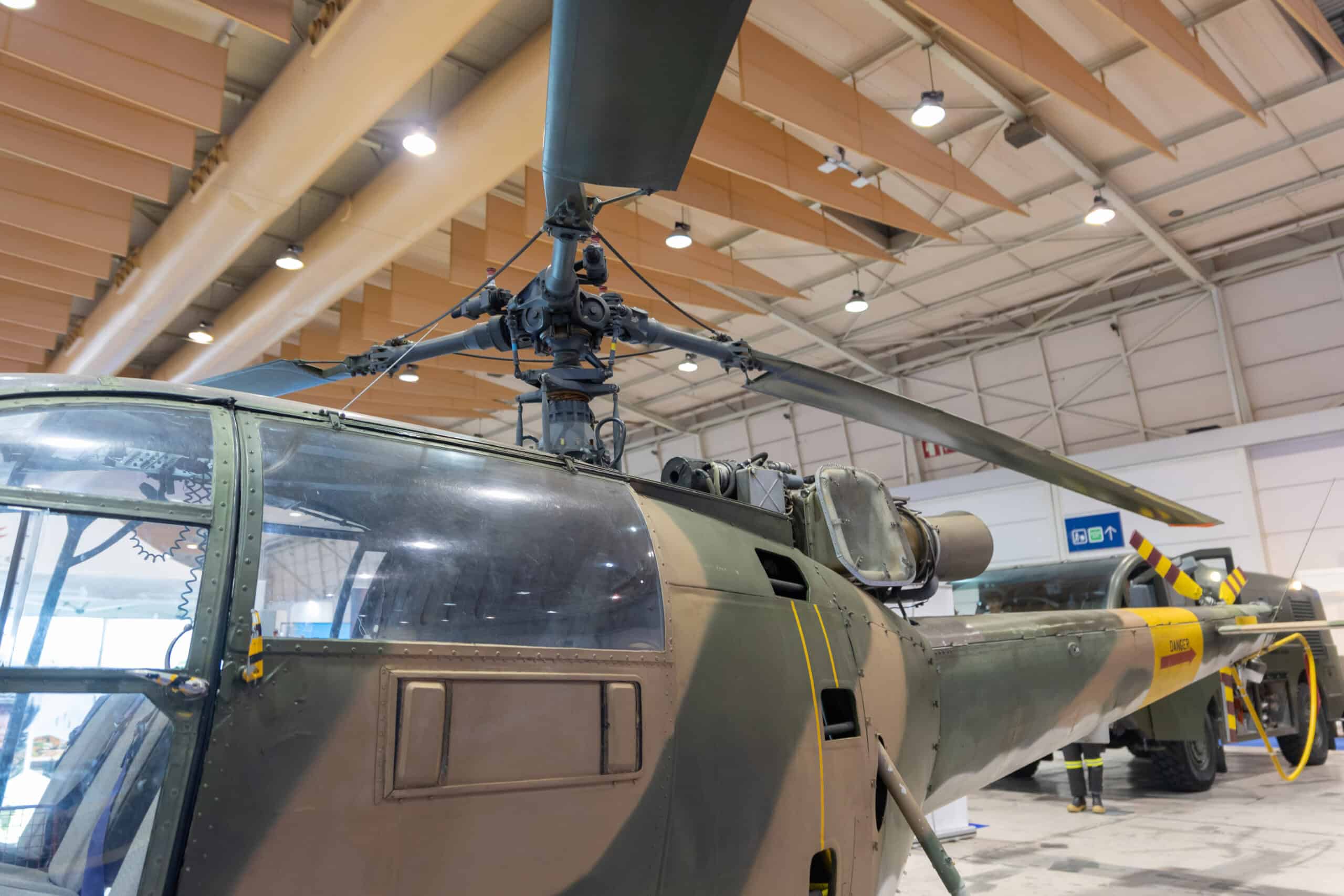 Military helicopter displayed indoors at an aviation exhibition.