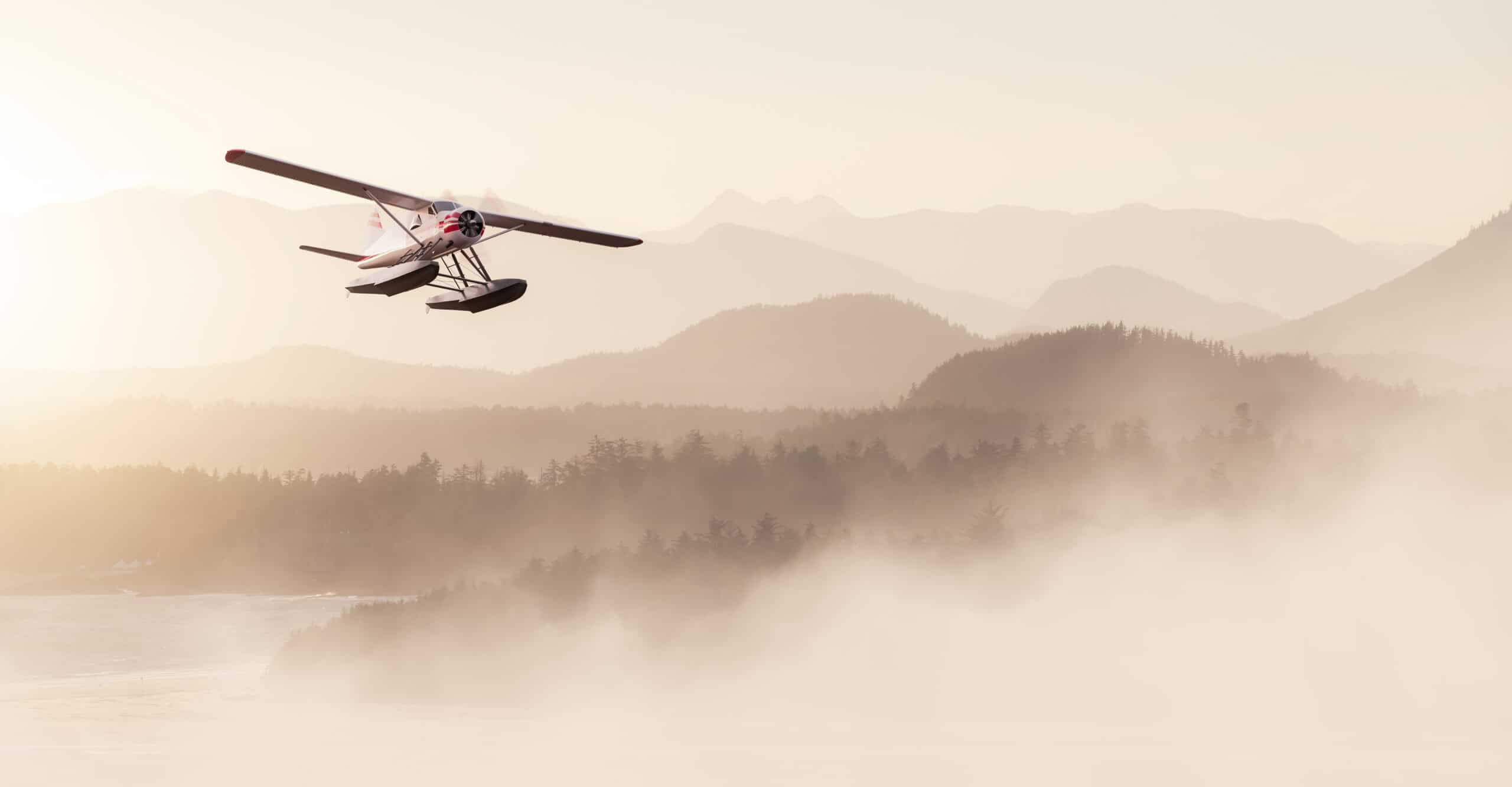 overwater flying safety — small floatplane in flight over misty Pacific coast