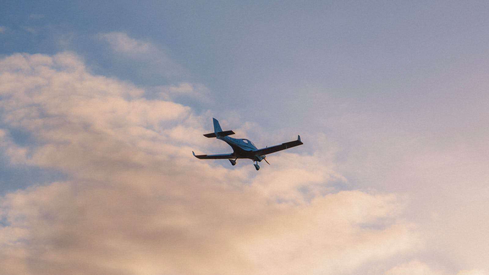 E3 Aviation Association aircraft flying in the sky at sunset.