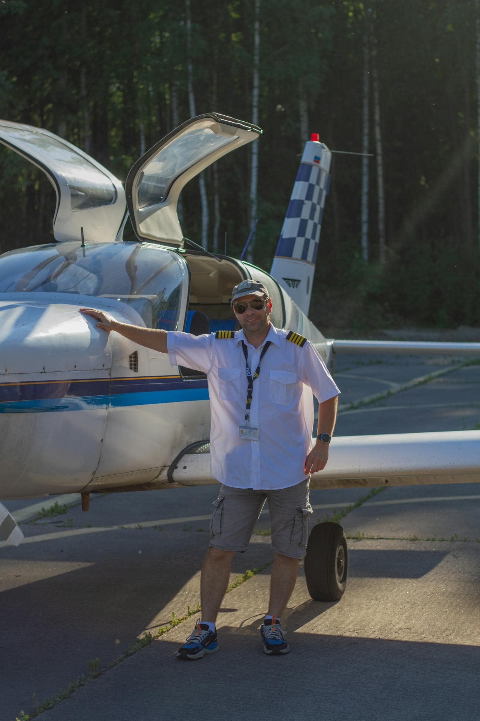 Pilot in uniform standing beside a small general aviation aircraft