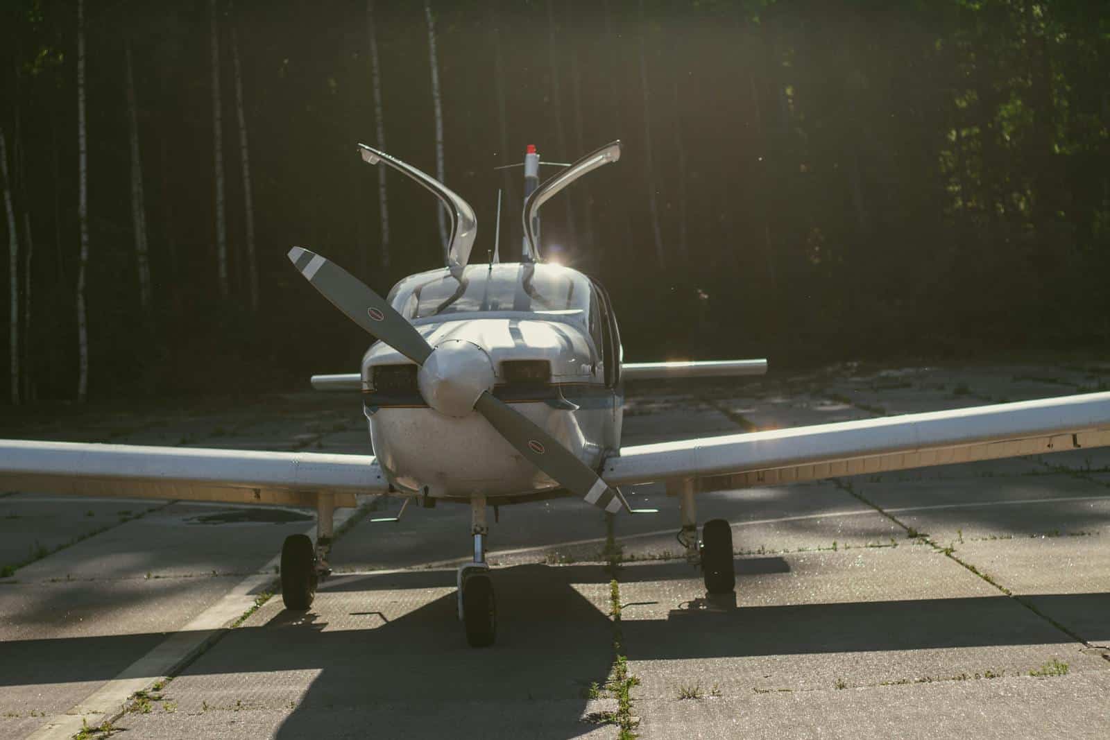 Aircraft with propeller on runway at sunset.
