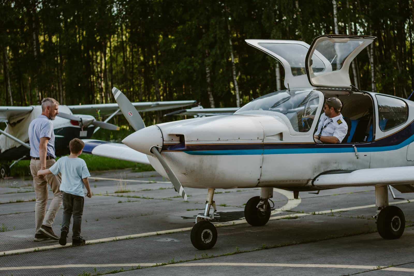 A father and son approaching a general aviation aircraft on a sunny day