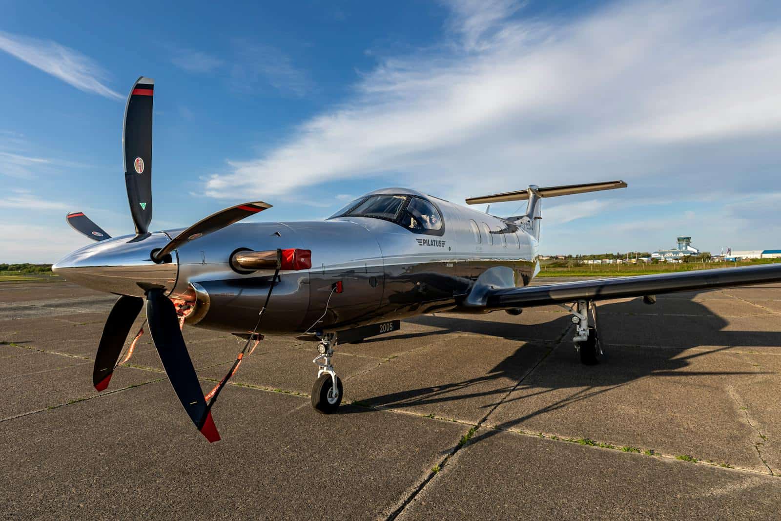 Modern turboprop aircraft parked on a runway under clear skies