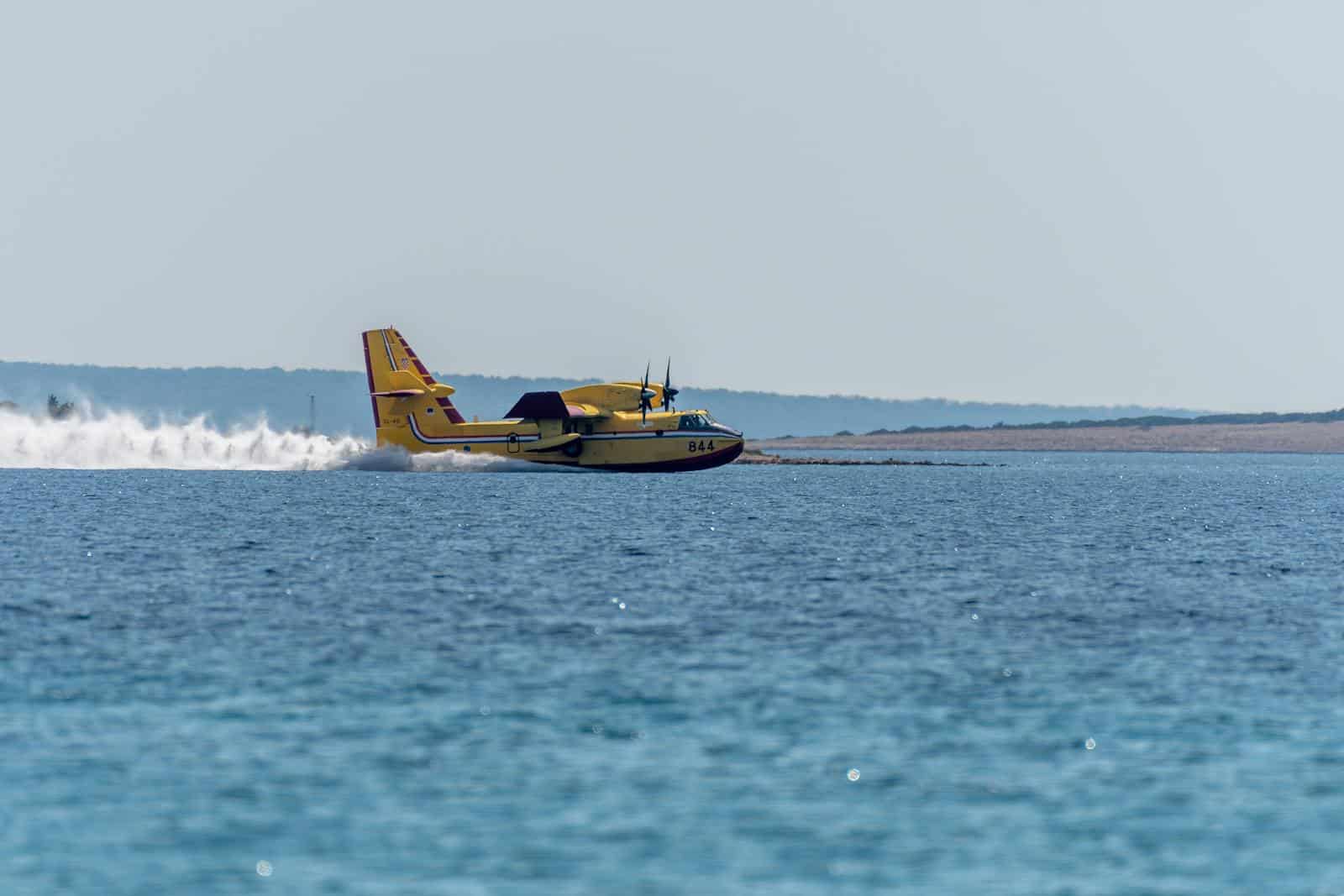 Seaplane skimming a calm water surface during takeoff