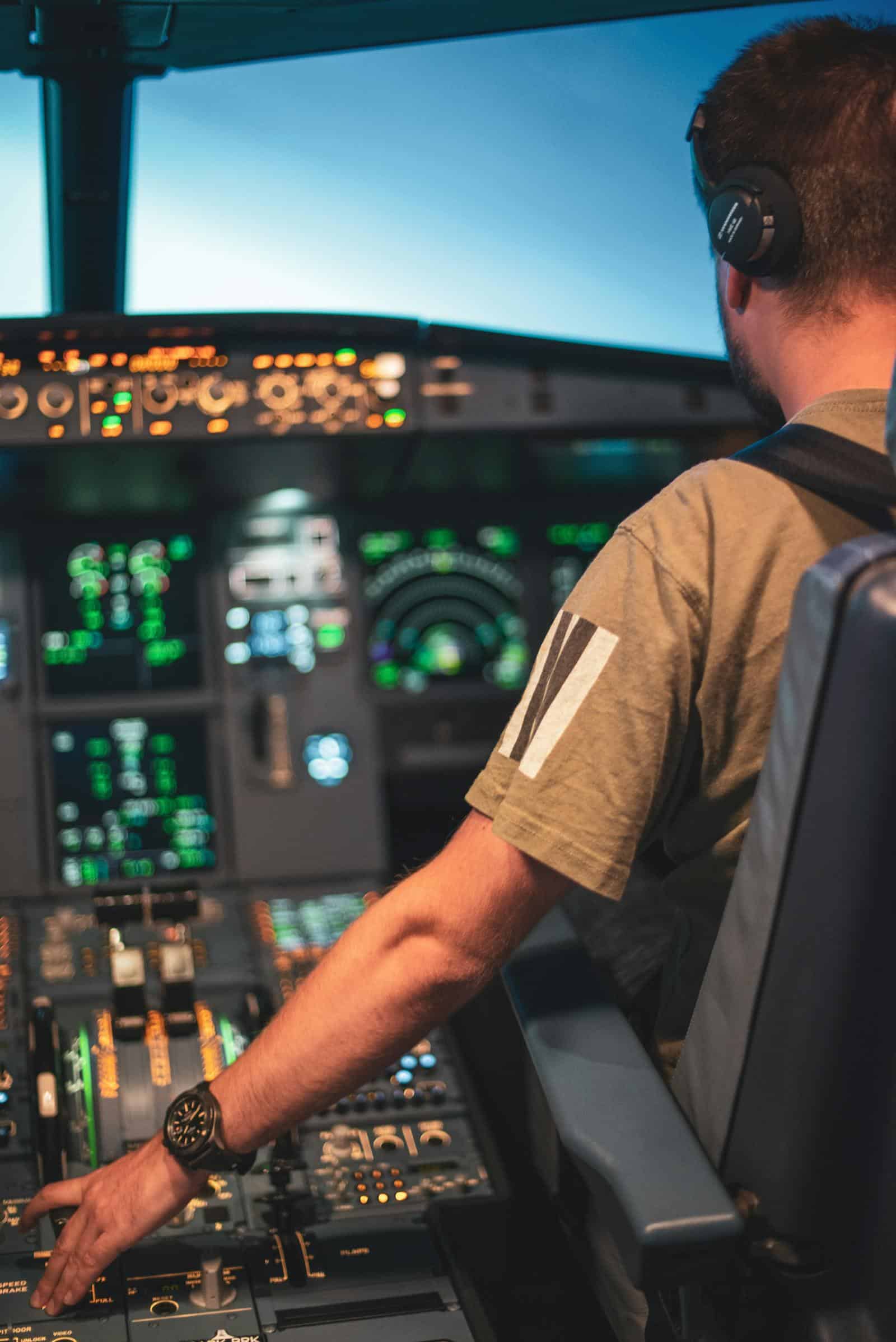 Pilot in an aircraft cockpit focusing on the control panel