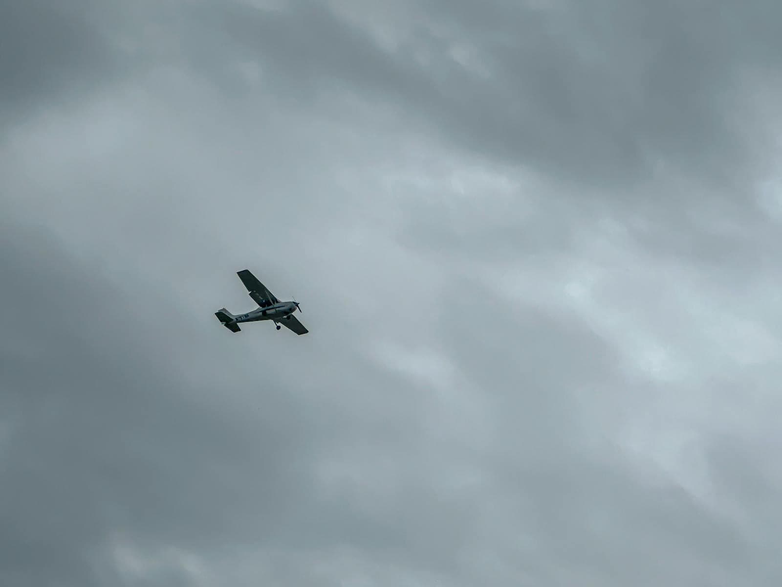 Single-engine aircraft navigating cloudy skies