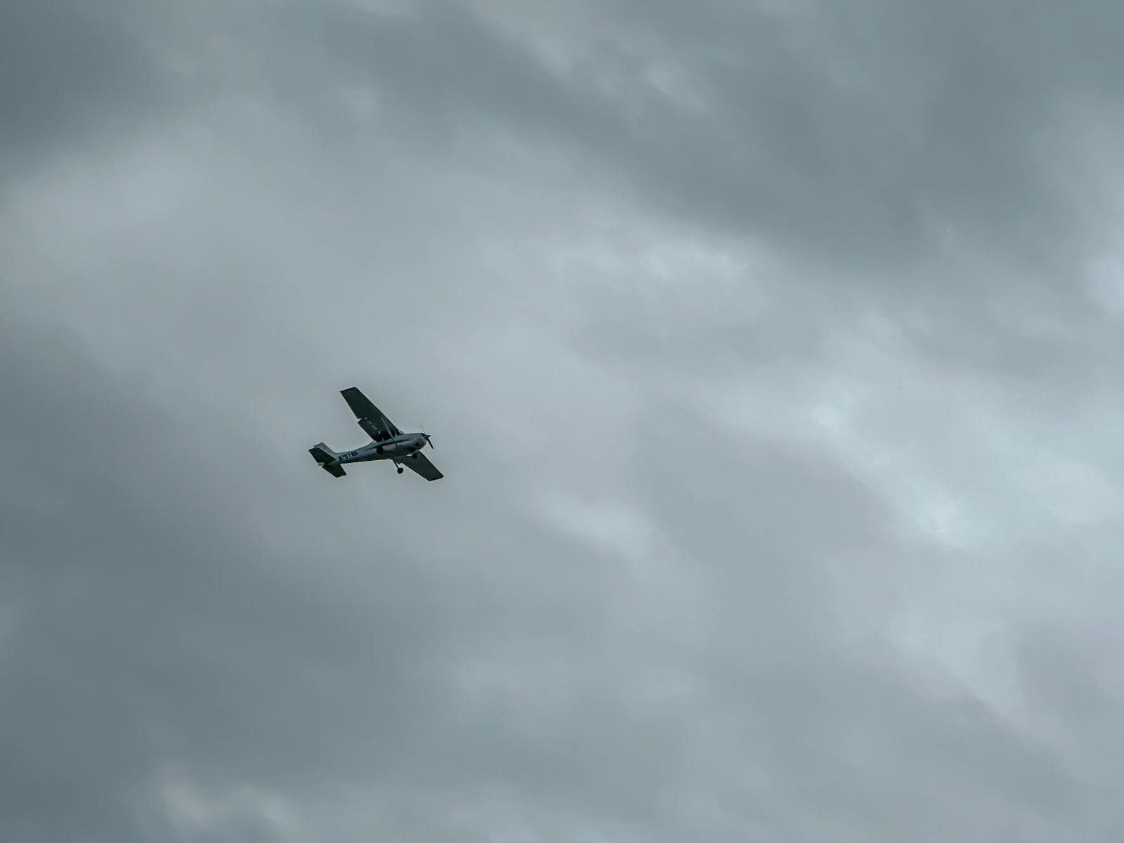 Single-engine aircraft navigating a cloudy sky