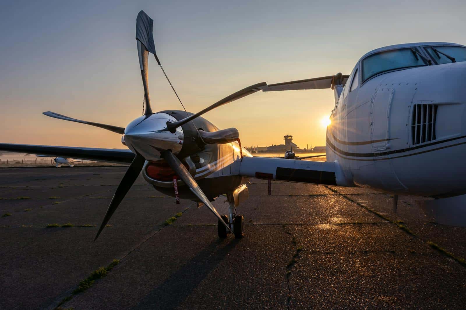 Aviation aircraft at sunset with the sun setting behind the plane on the runway.