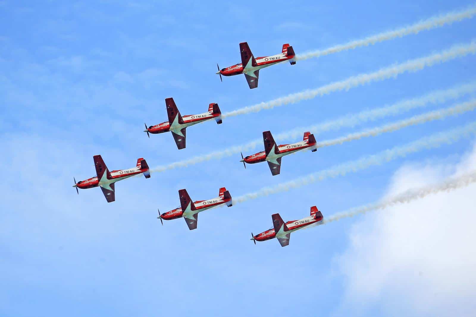 Aerobatic aircraft in formation against a clear blue sky
