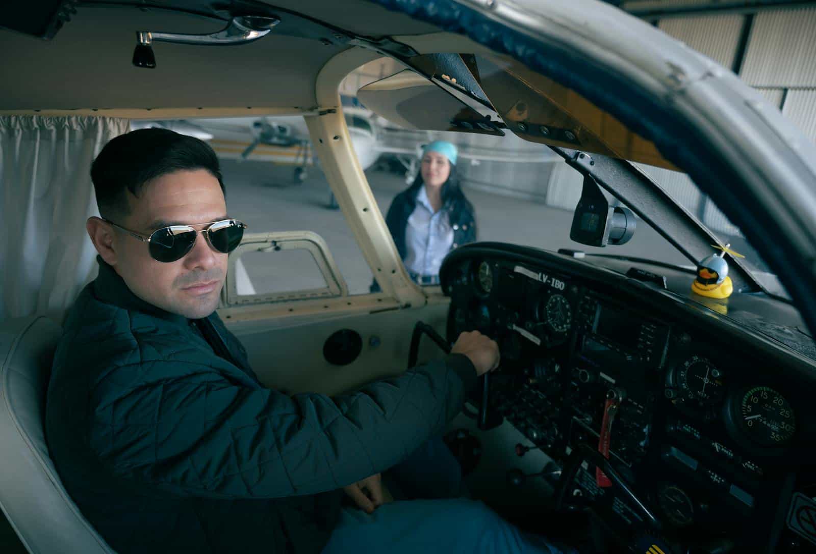 Pilot in the cockpit of a general aviation aircraft with crew in the background