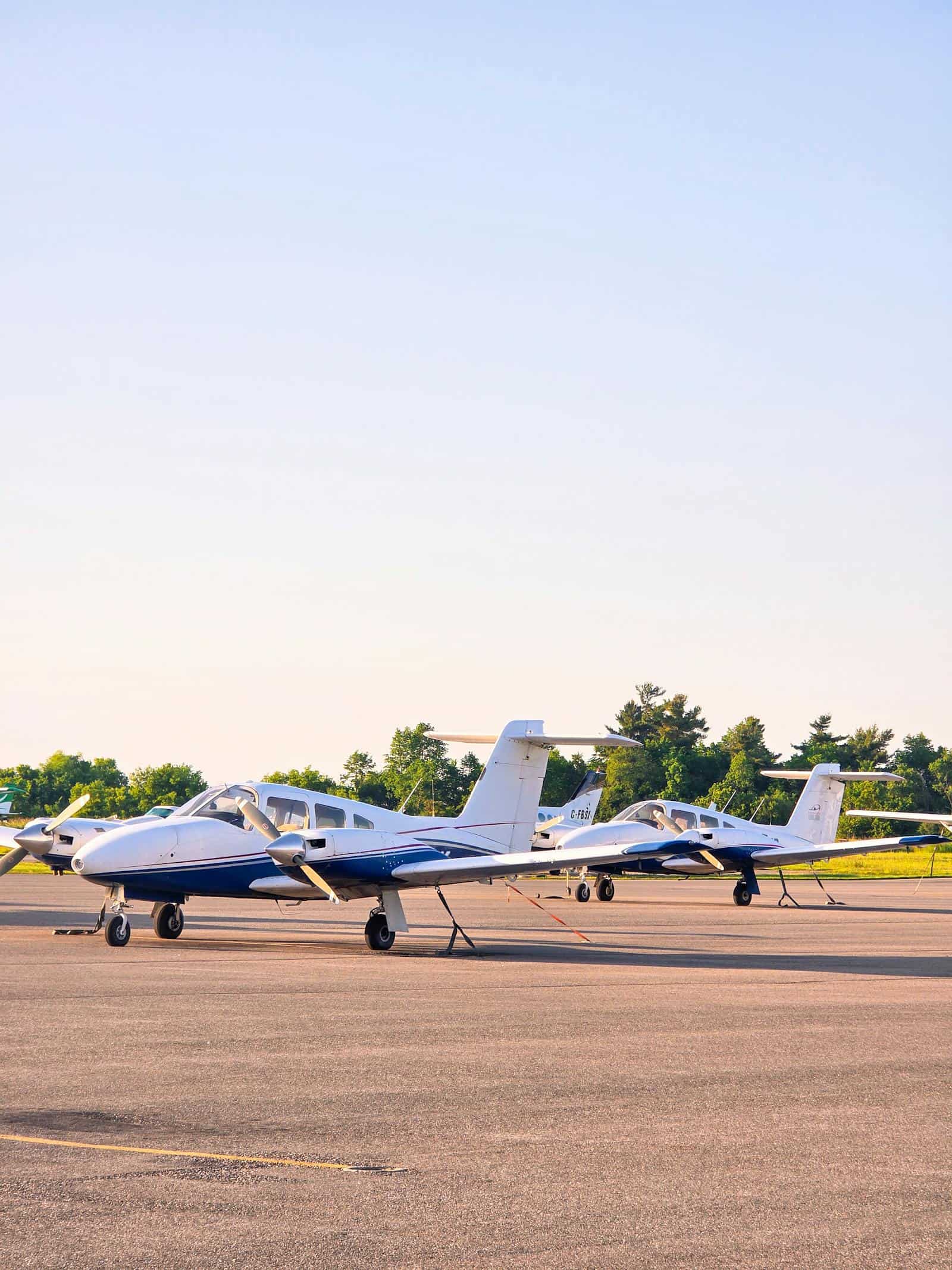 Two small private planes stationed outdoors on a sunny day