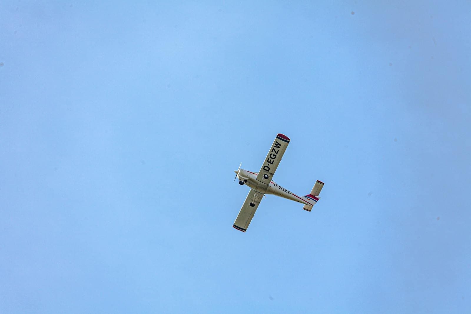 Small aircraft captured mid-flight against a clear blue sky