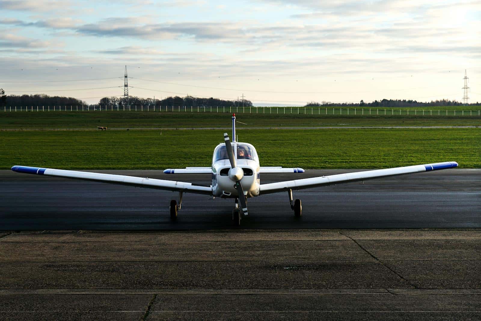 Small propeller airplane parked on a runway at sunset