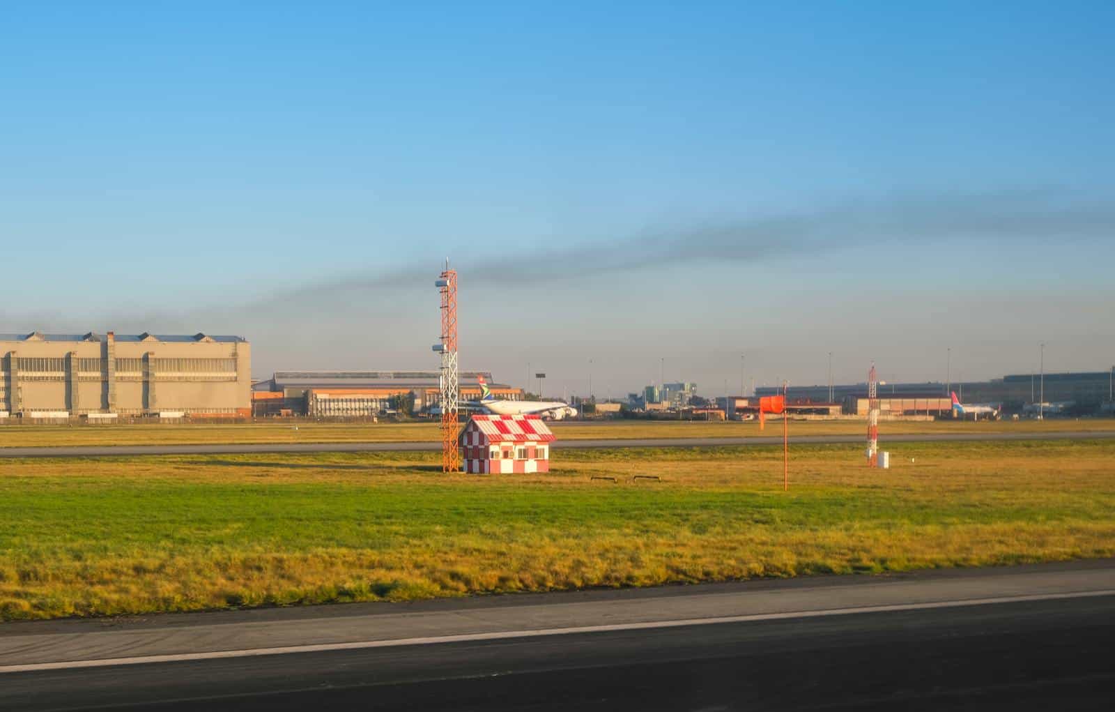 Small airport runway with hangars under a clear sky