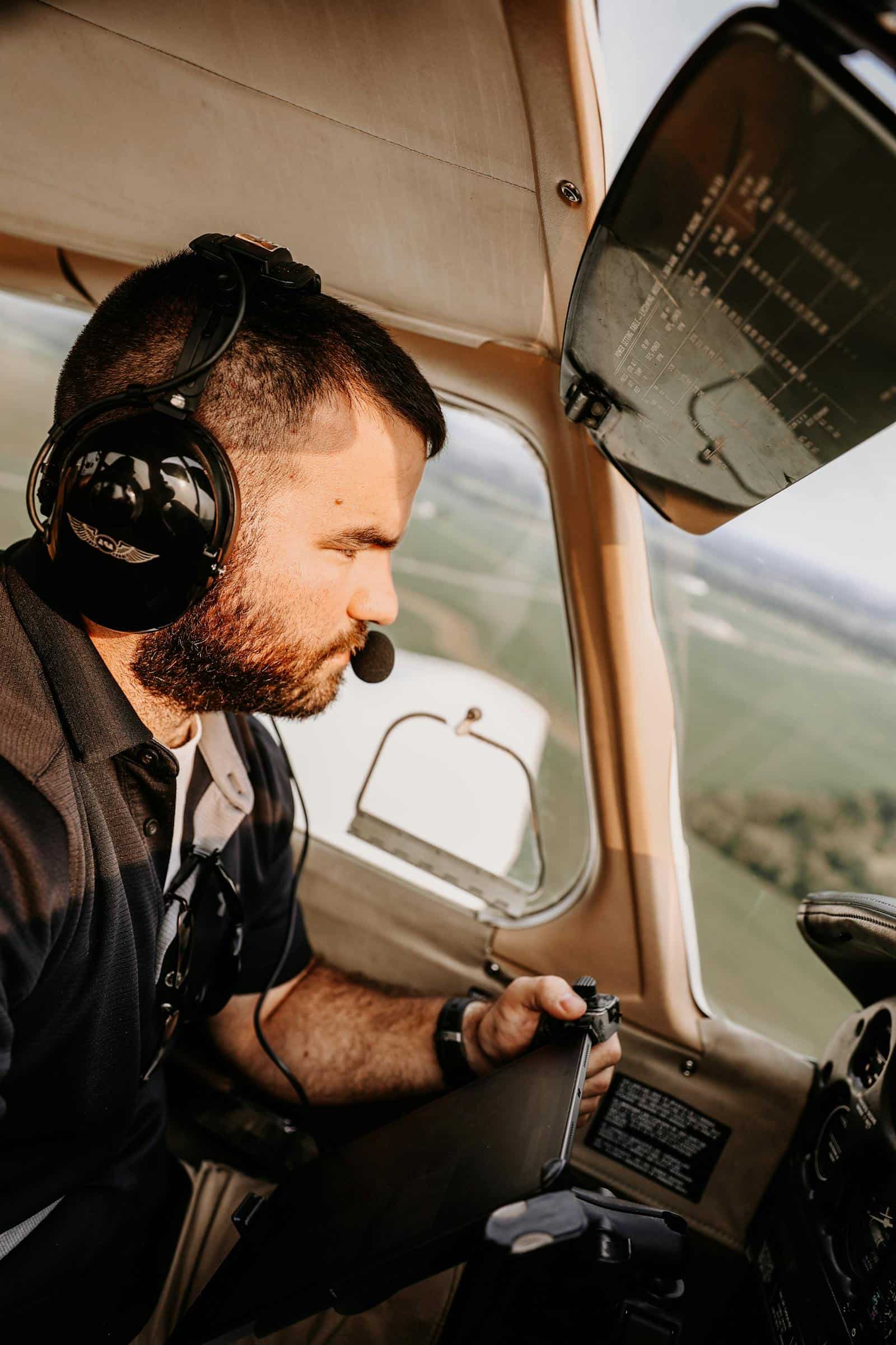 Pilot wearing a headset operating a general aviation aircraft