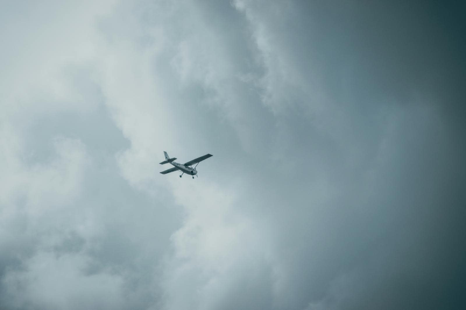 Small aircraft flying through thick overcast clouds