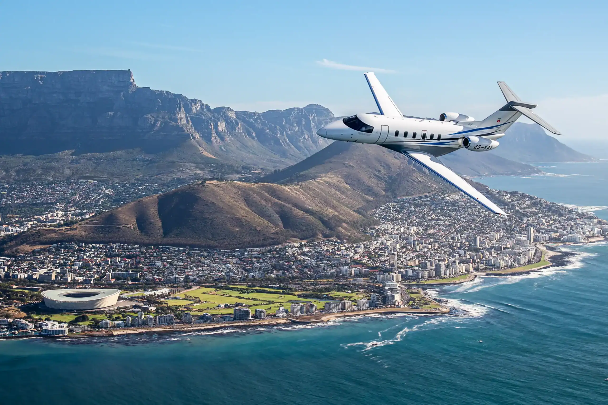 Private jet soaring above Cape Town with Table Mountain scenery.
