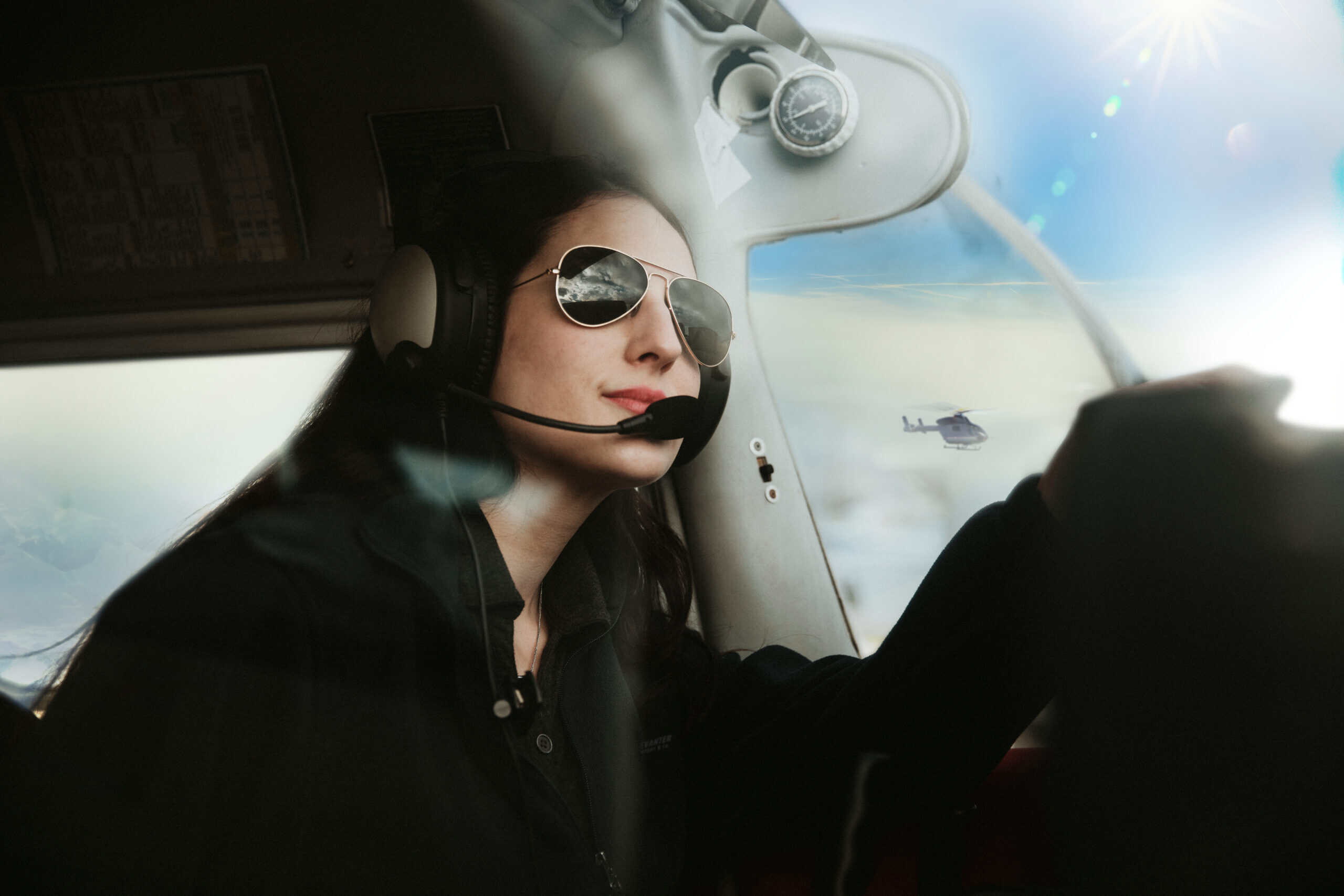 Smiling female pilot in cockpit of small aircraft