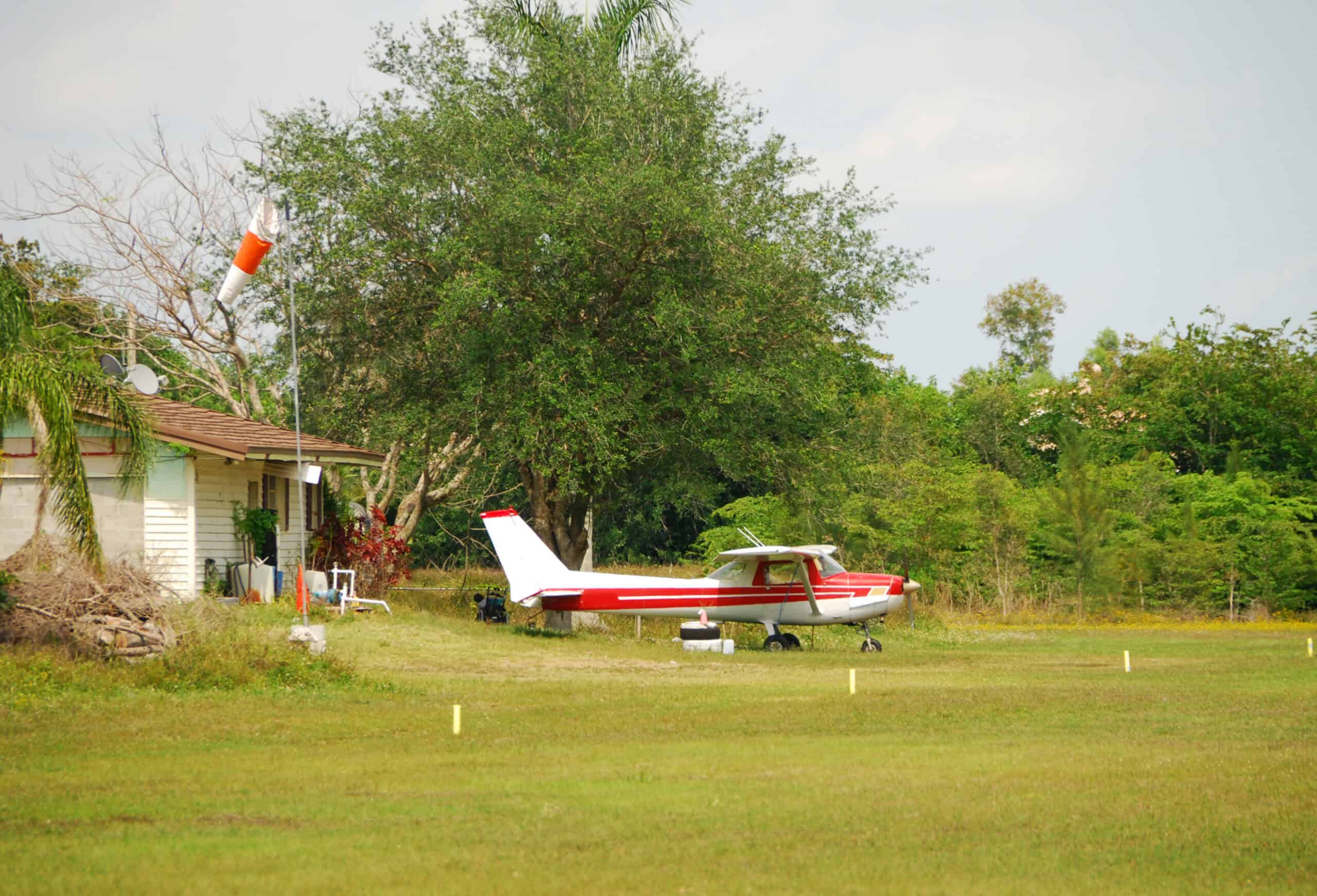 GA pilot preparing camping gear beside aircraft for cross-country airplane camping trip