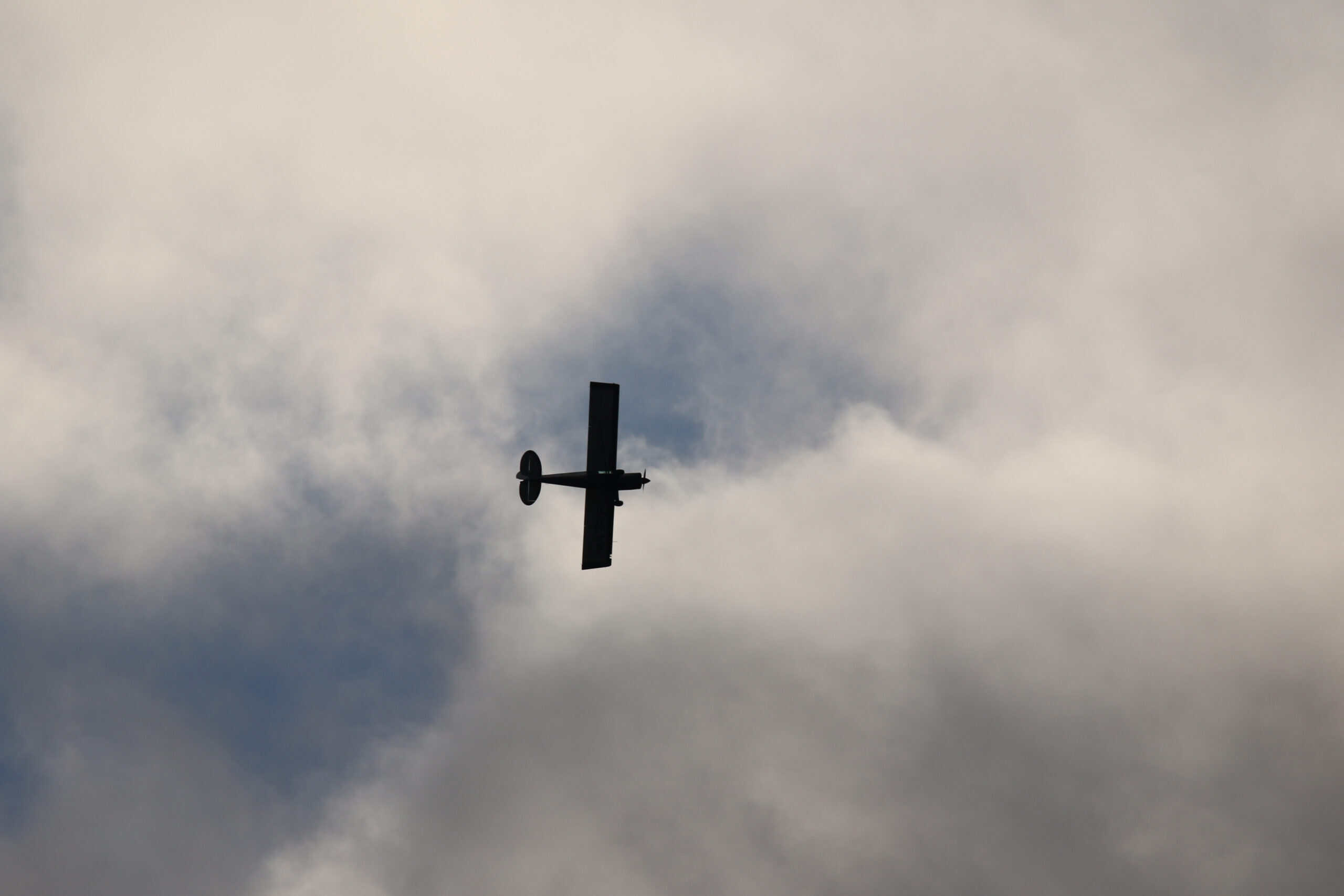 Small piston single airplane flying toward dark weather clouds — CFIT awareness for GA pilots
