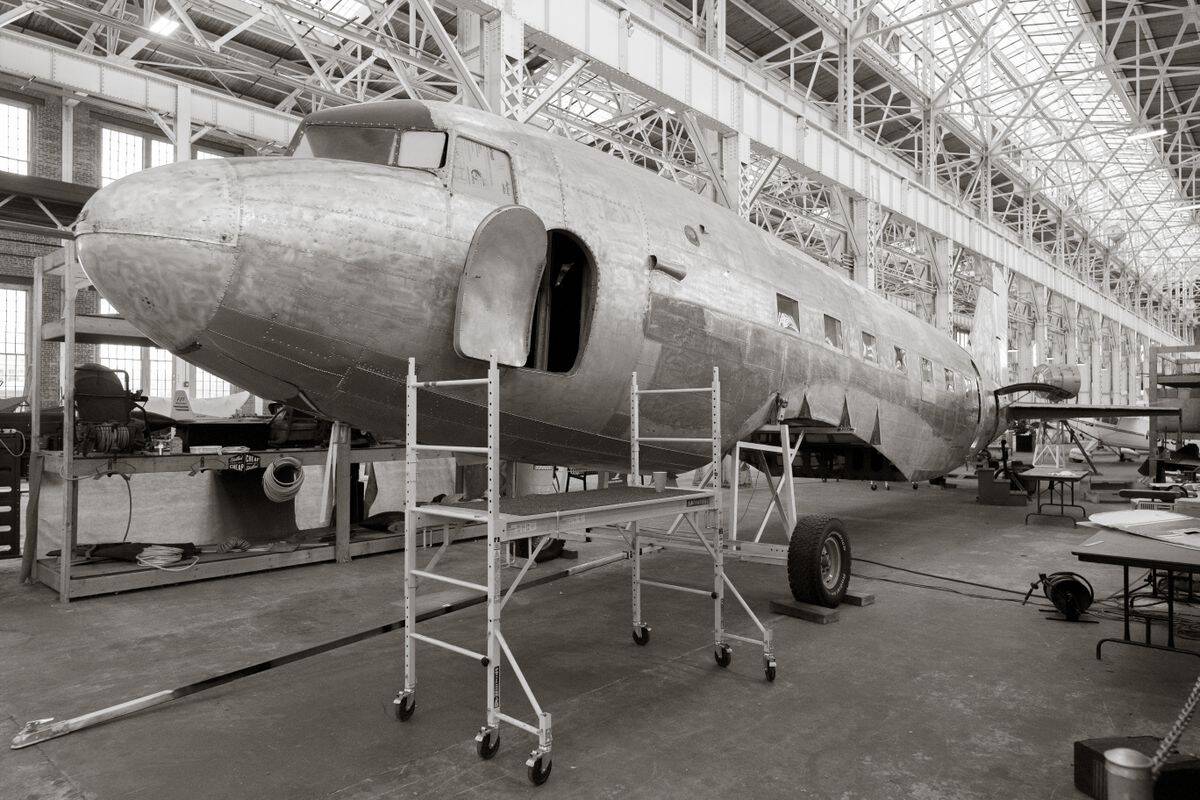 Vintage aircraft under restoration showing skin corrosion treatment points