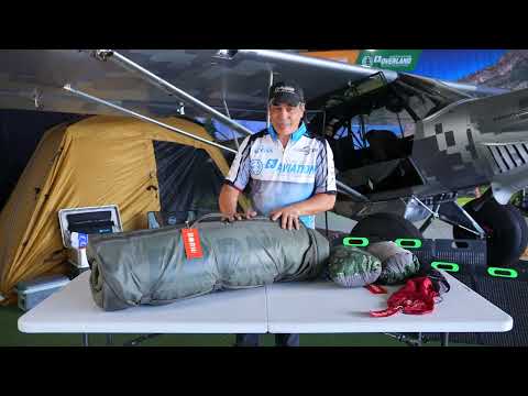 The Born Outdoor airplane camping bedroll fully rolled on a folding table, ready for loading into a Carbon Cub baggage compartment.