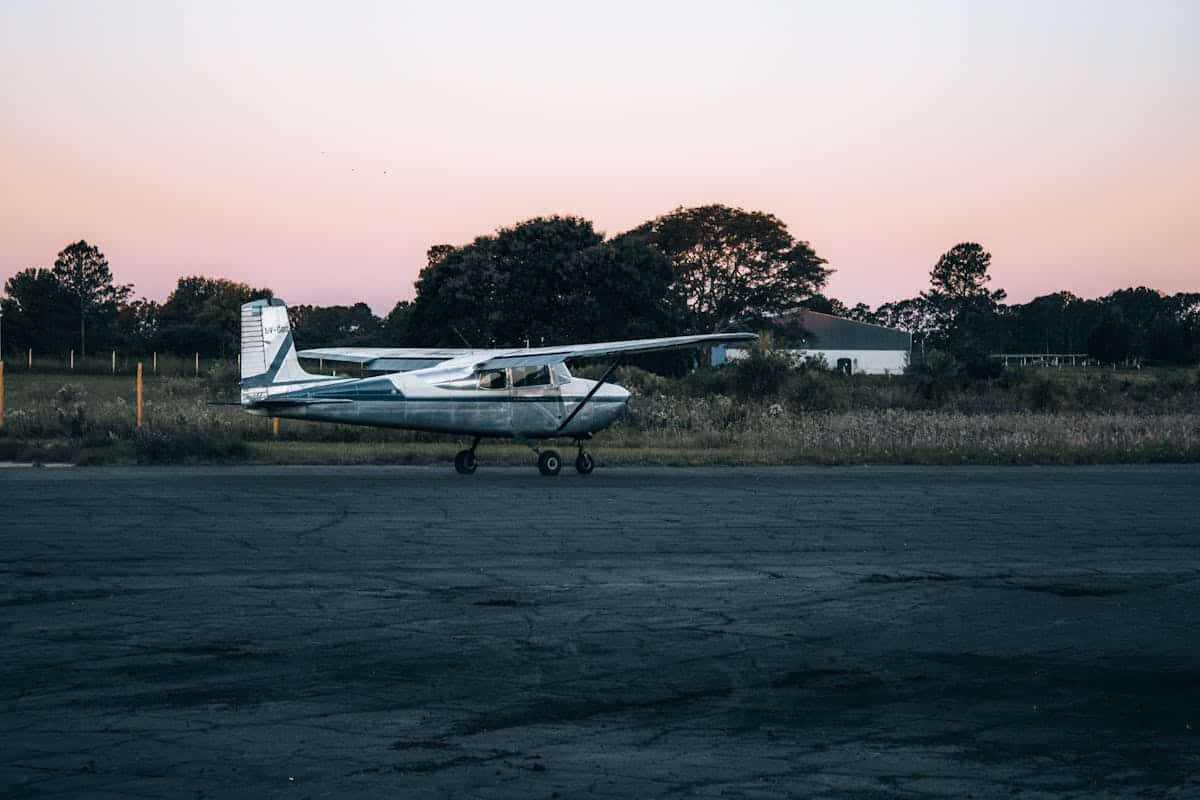 Small aircraft parked on a rural runway at sunset