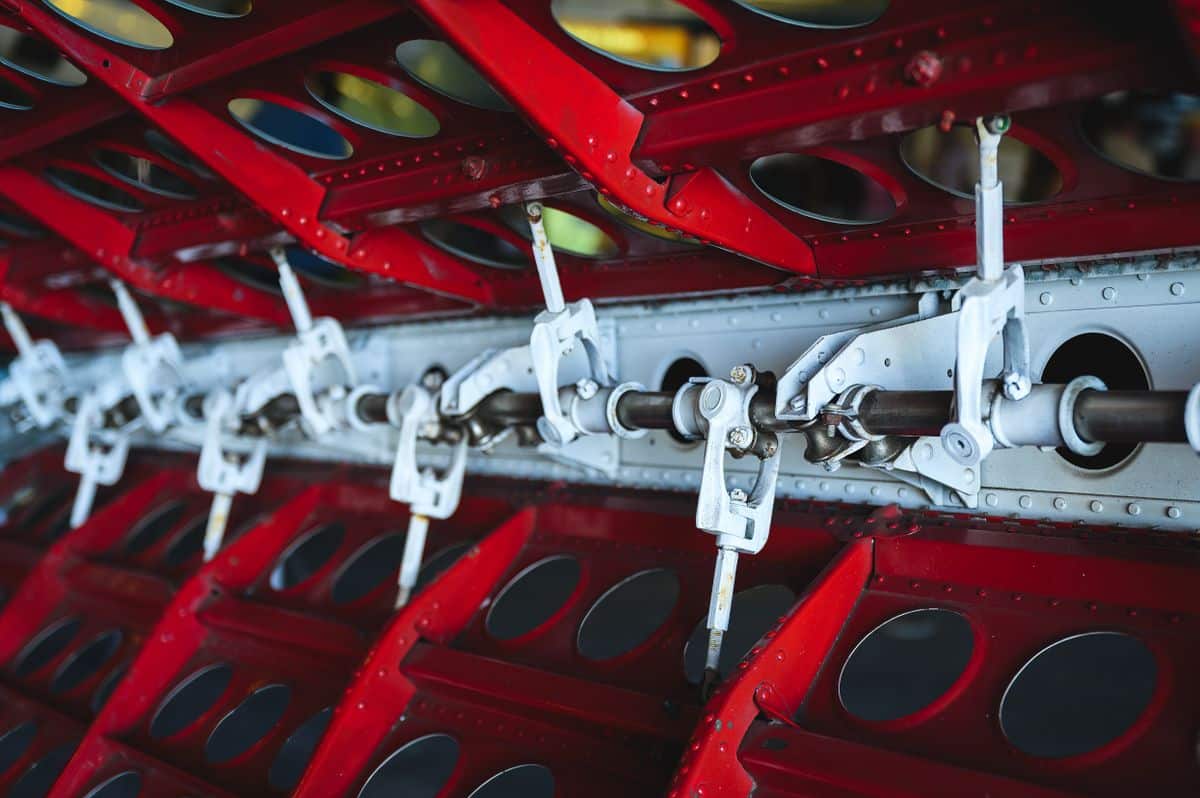 Close-up view of aircraft wing mechanism with metal levers